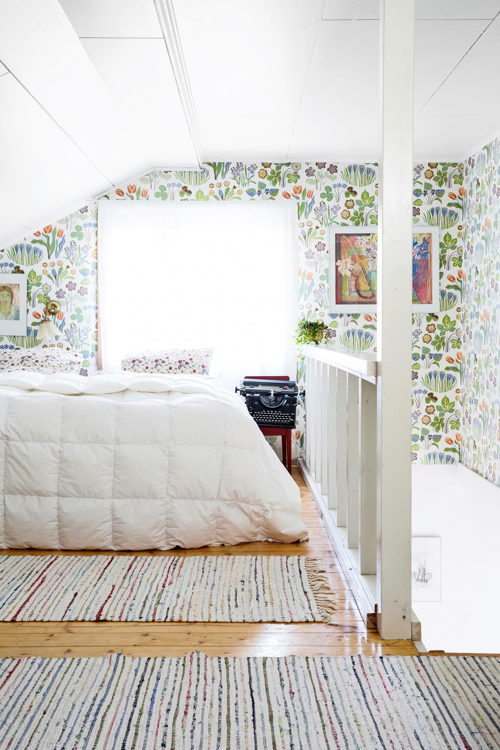 Traditional floral wallpaper, Josef Frank’s Vårklockor, in the guest bedroom of a 1940s house