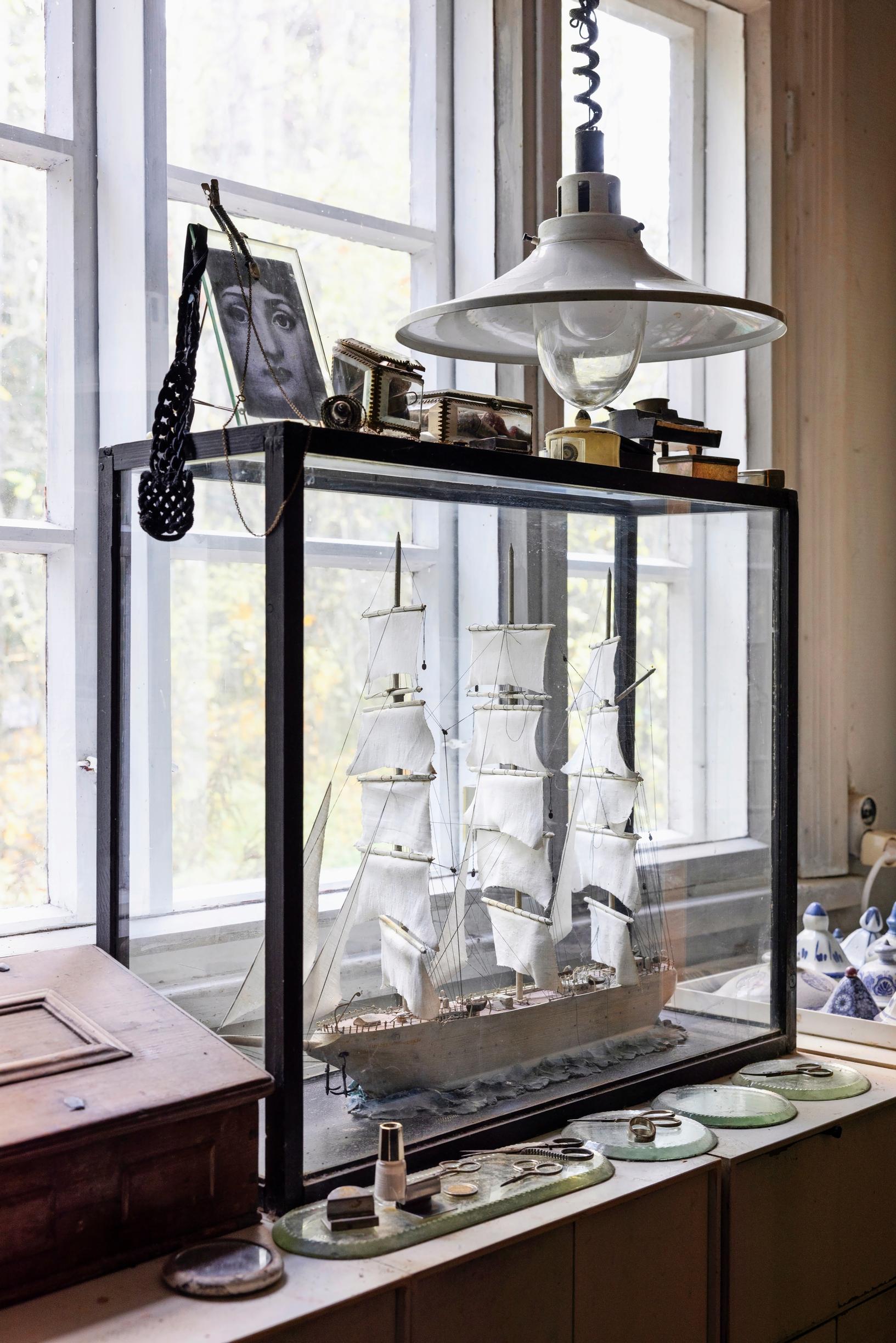 A model sailing ship in front of a window.