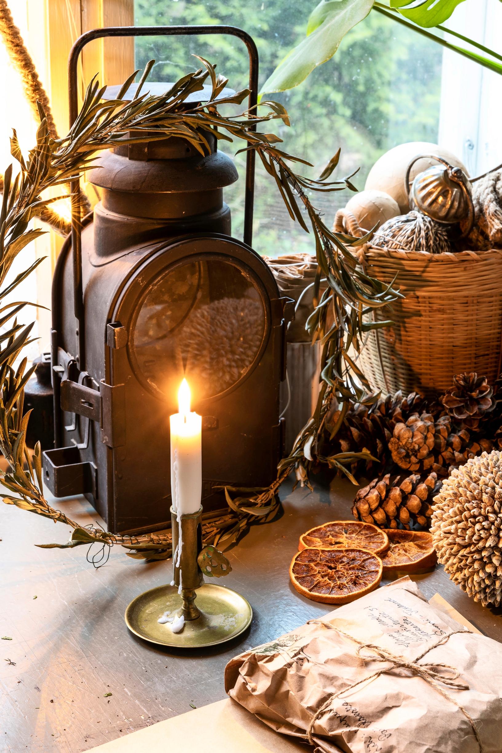 A candle, pinecones, and gift-wrapping supplies