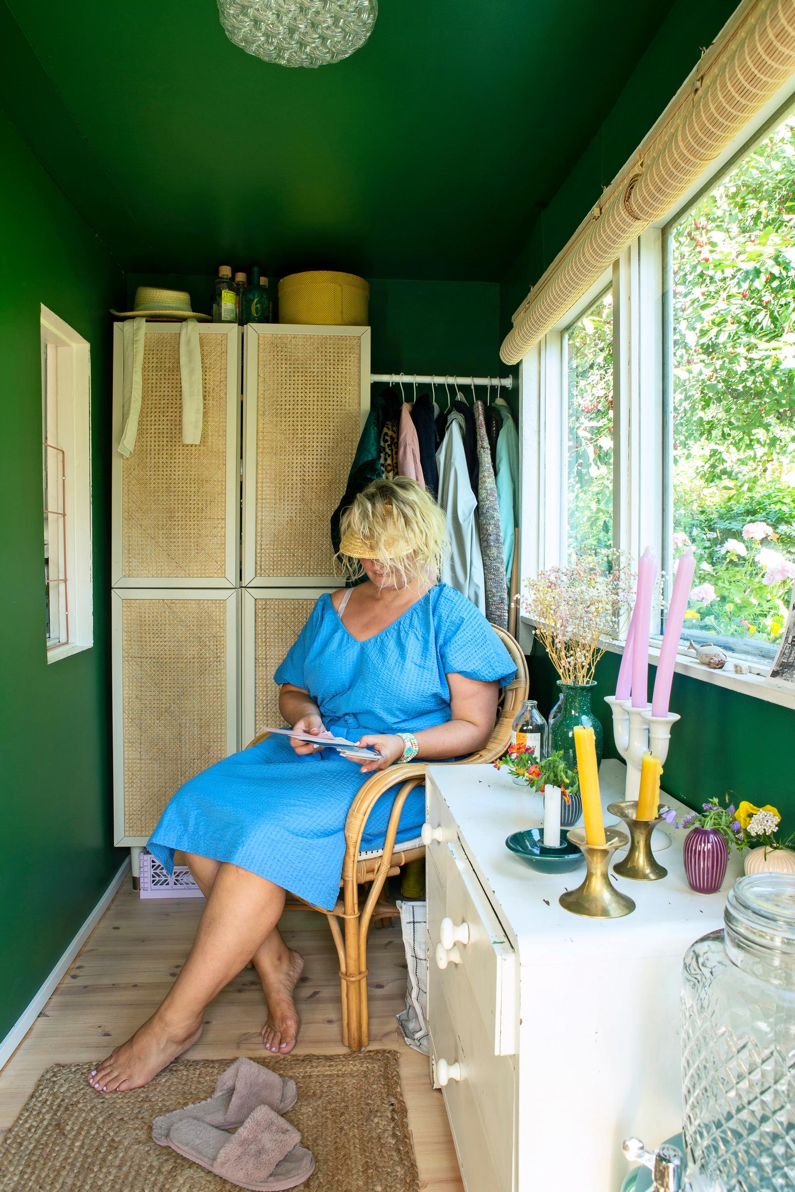 Laura in the green-painted entryway of her community garden cottage