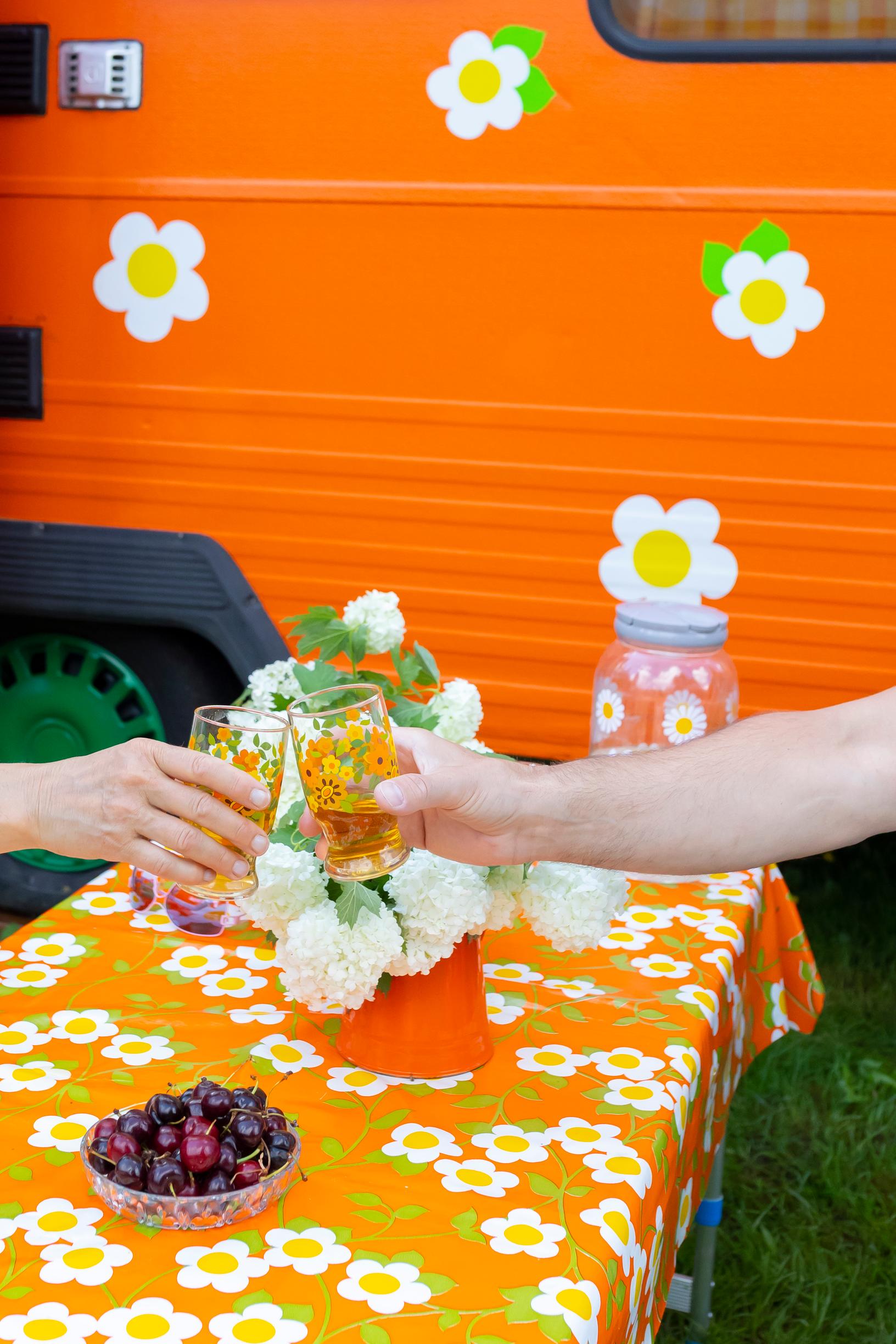 hands raising a toast over a colorful floral tablecloth