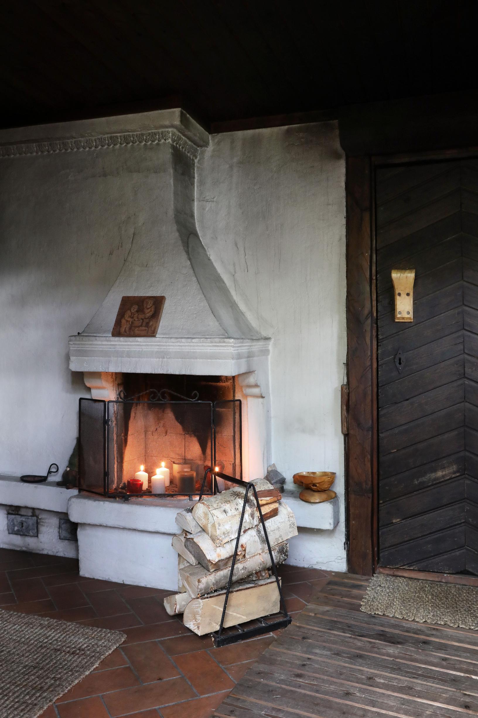 The whitewashed open fireplace holds candles.