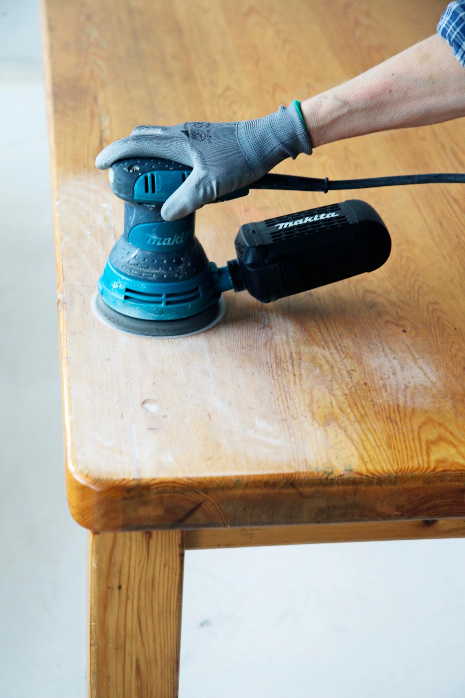 Sanding off the old varnish from the table