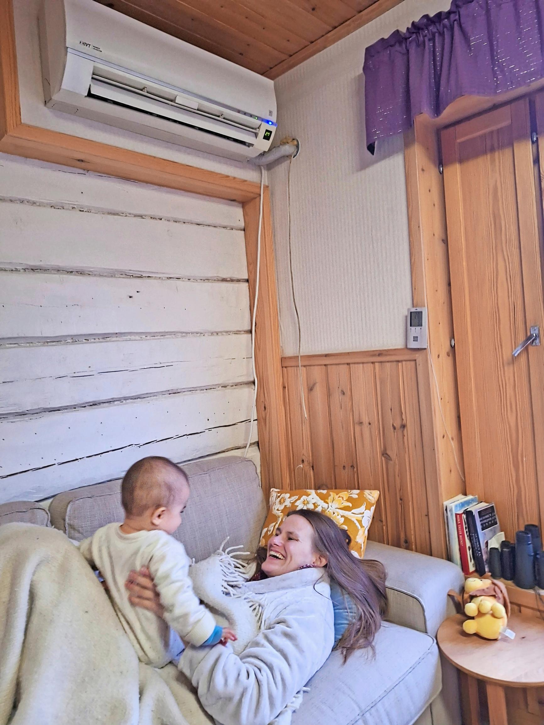 woman holding a child in her arms, both laughing