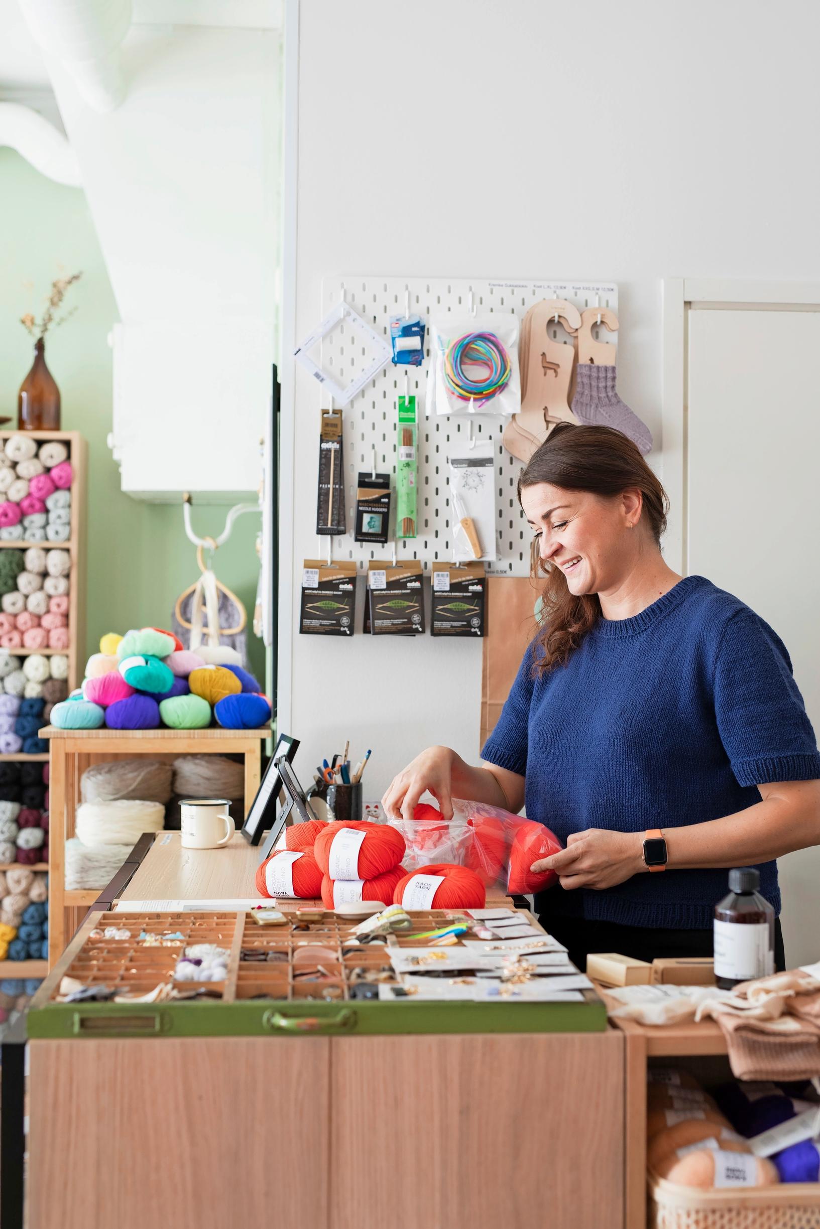 Woman at a desk unpacking yarn skeins