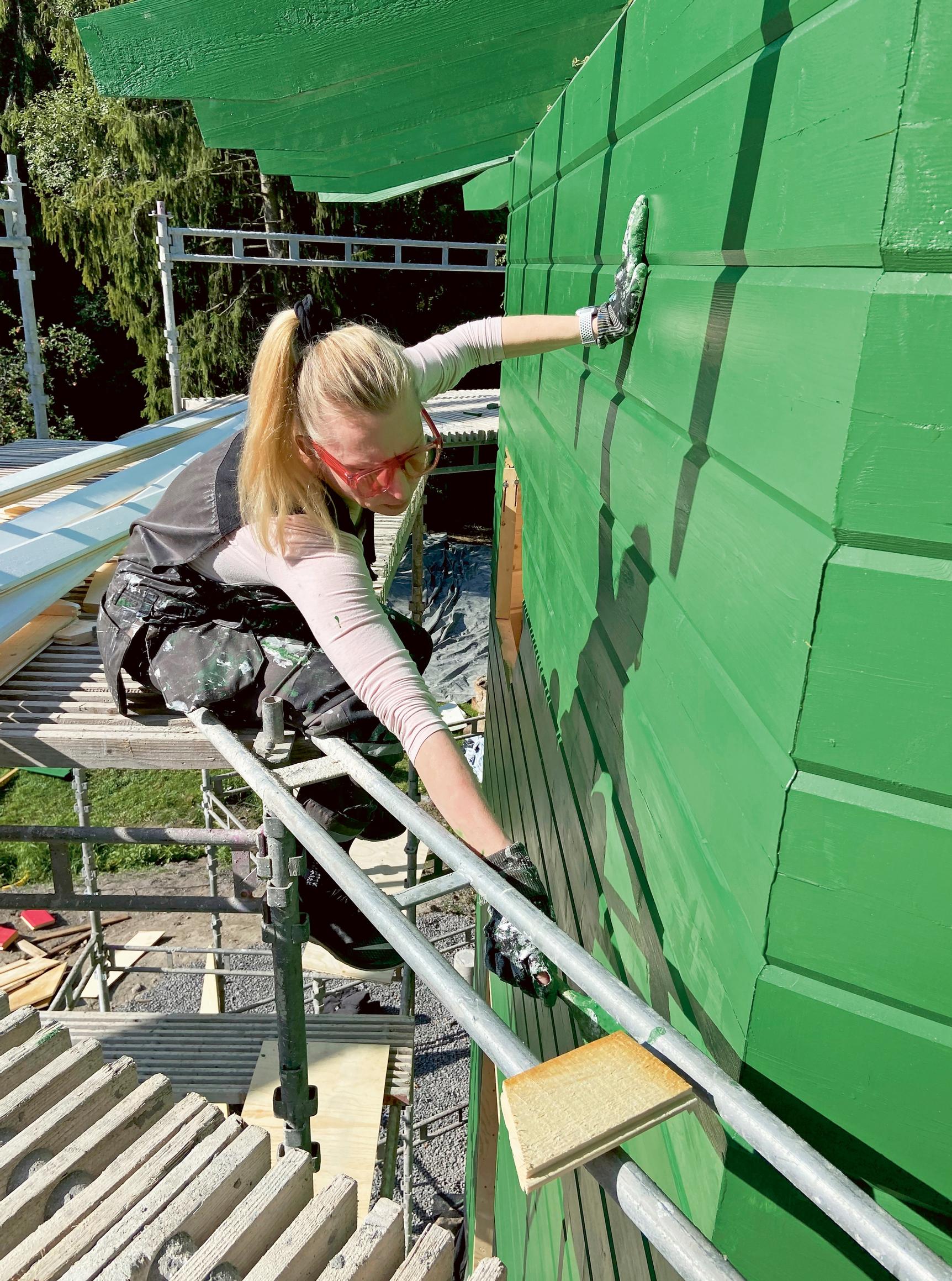 Marjo painting the house