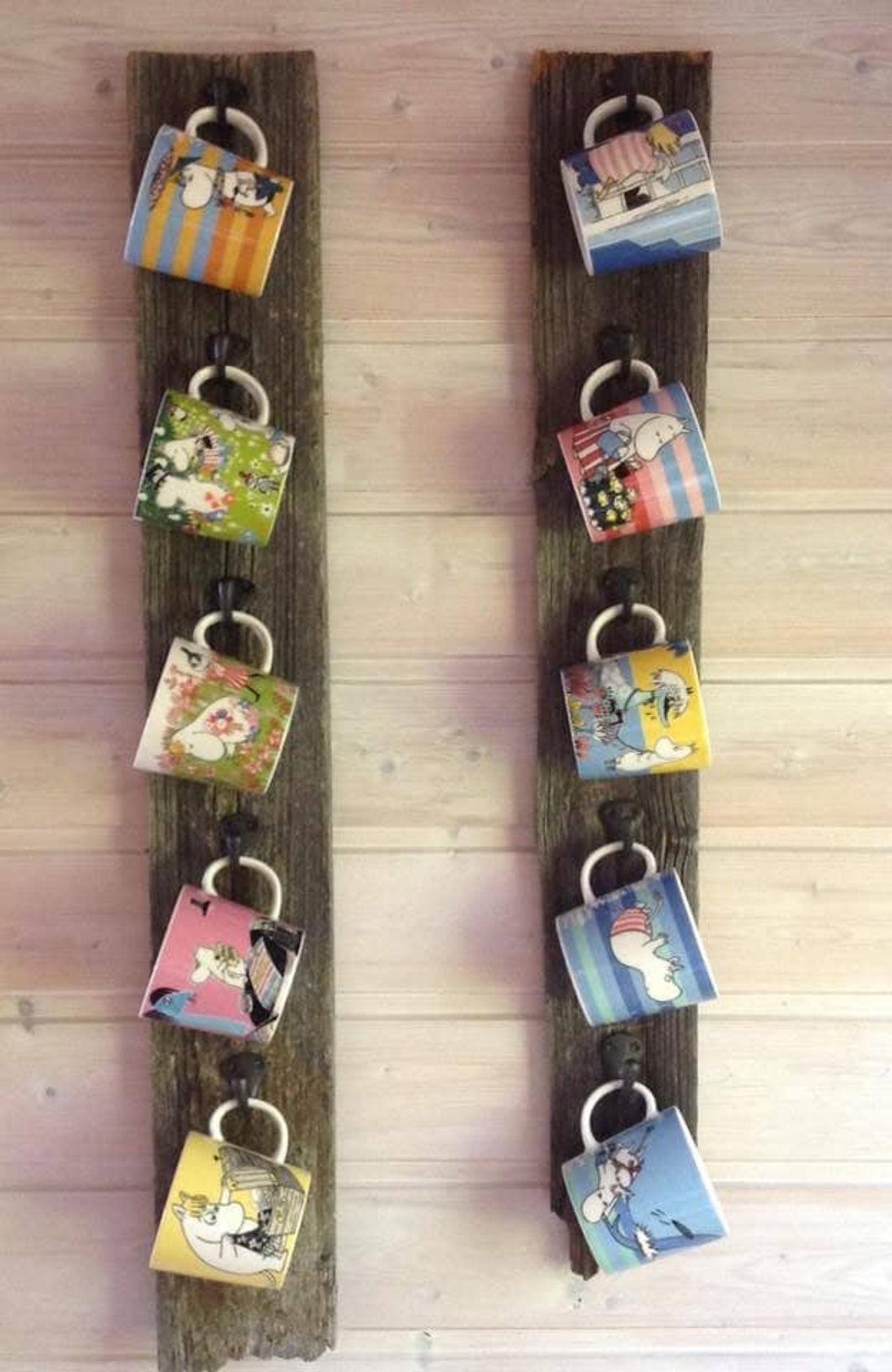Moomin mugs hung on two vertical planks
