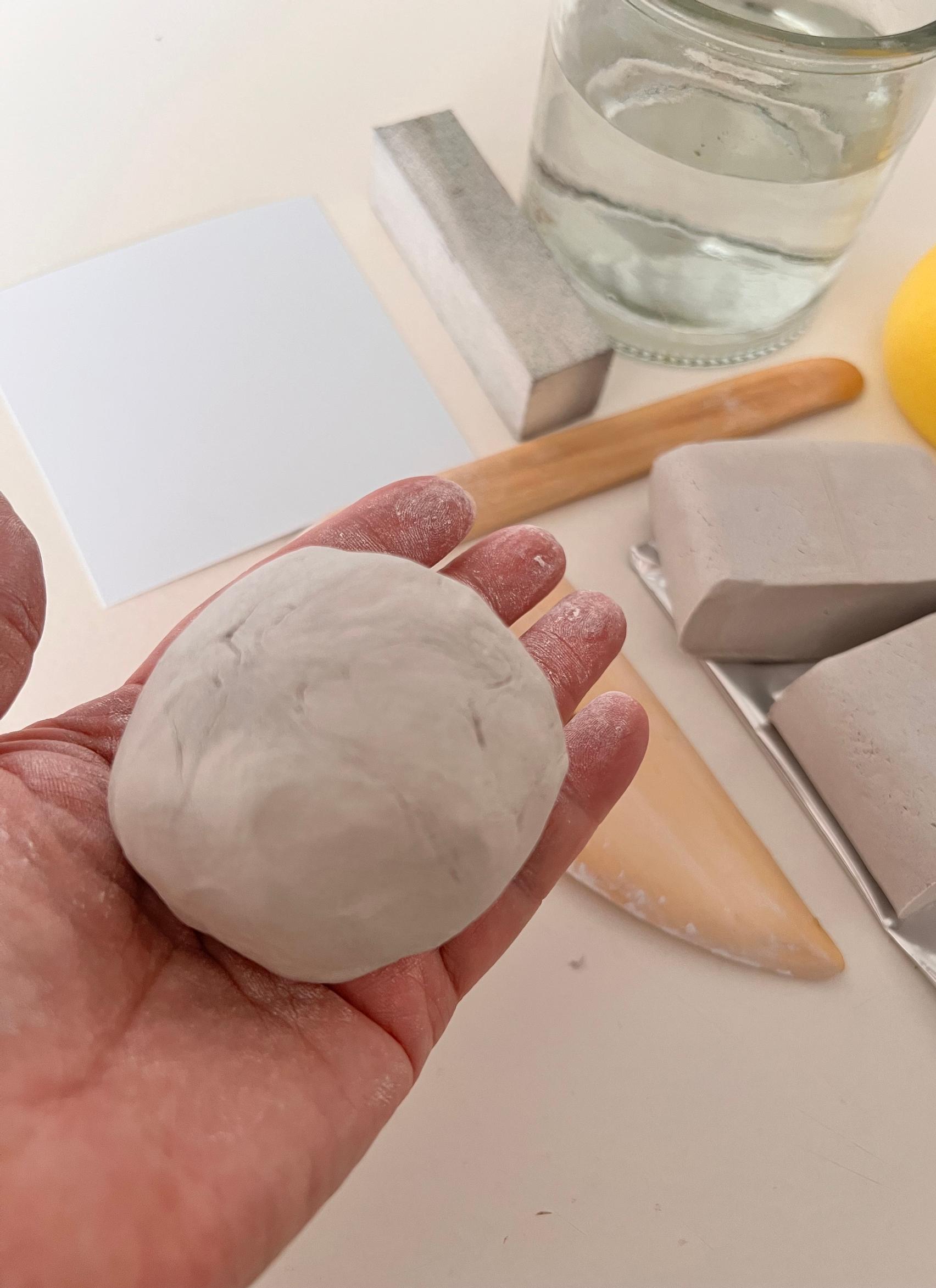 The clay is shaped into a ball in the palm of the hand.