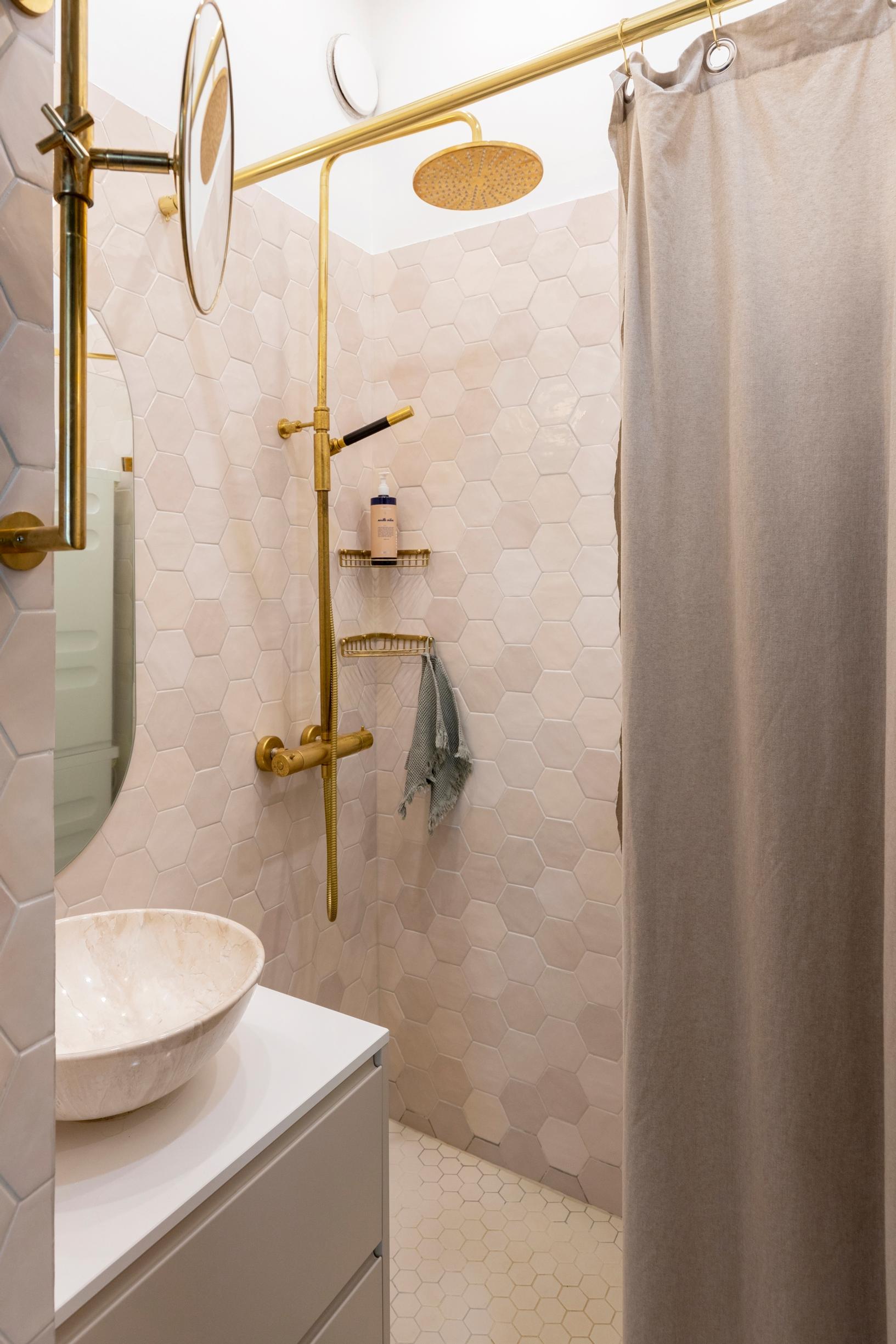 A shower curtain in a small, light-colored bathroom