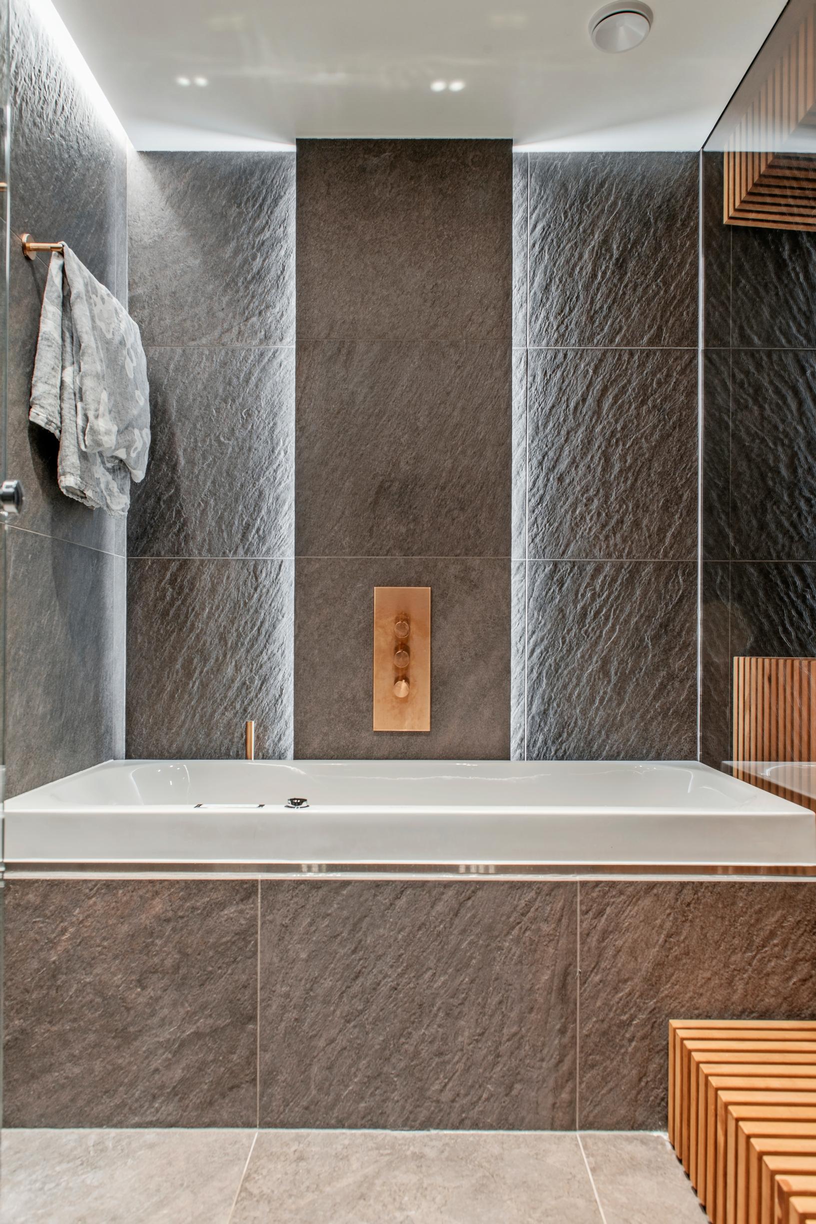 Striking, atmospheric indirect lighting and a bathtub in the bathroom