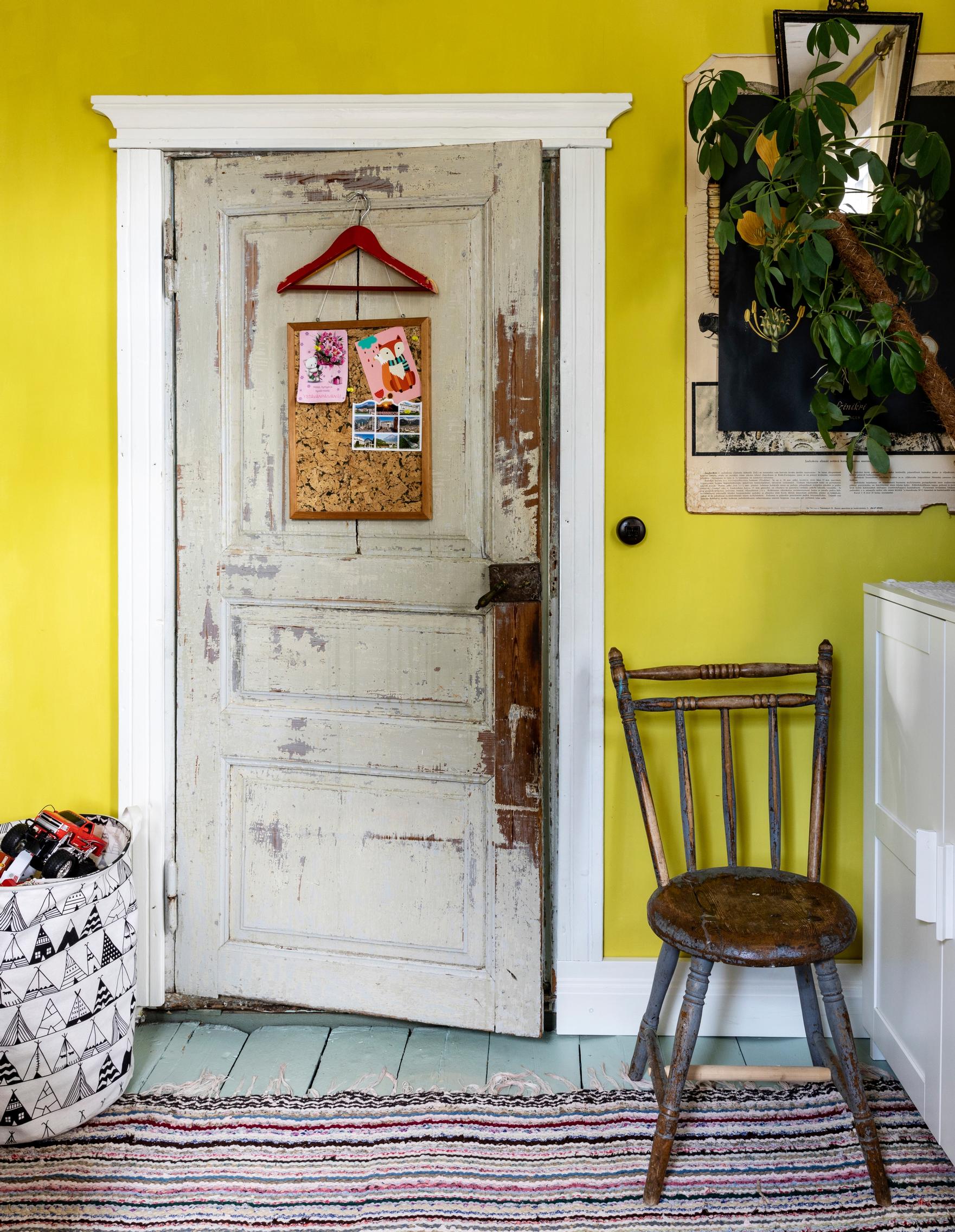 wide white baseboards and door trim in a room with yellow walls and a rag rug on the floor
