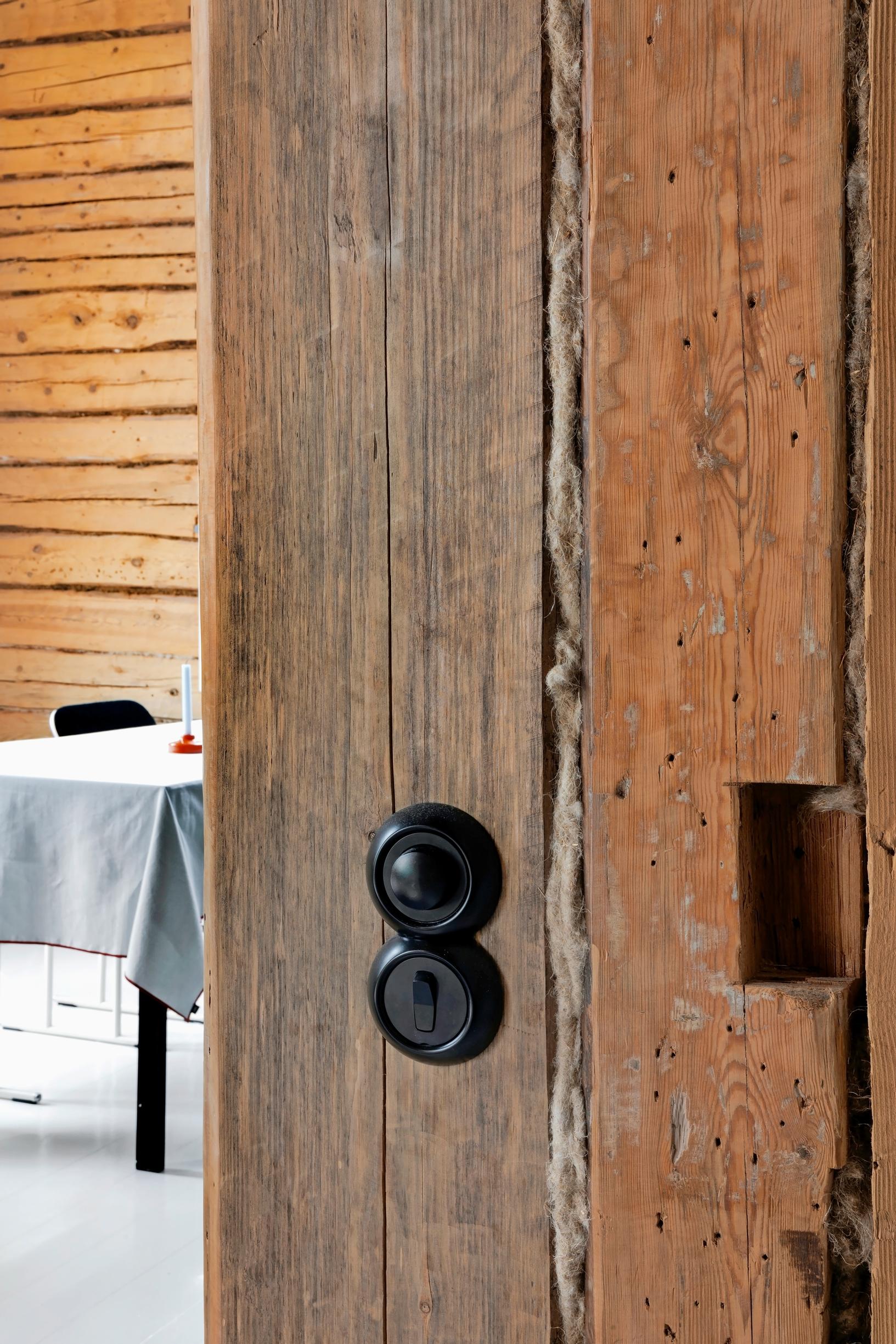 Old-fashioned light switches on a log wall.