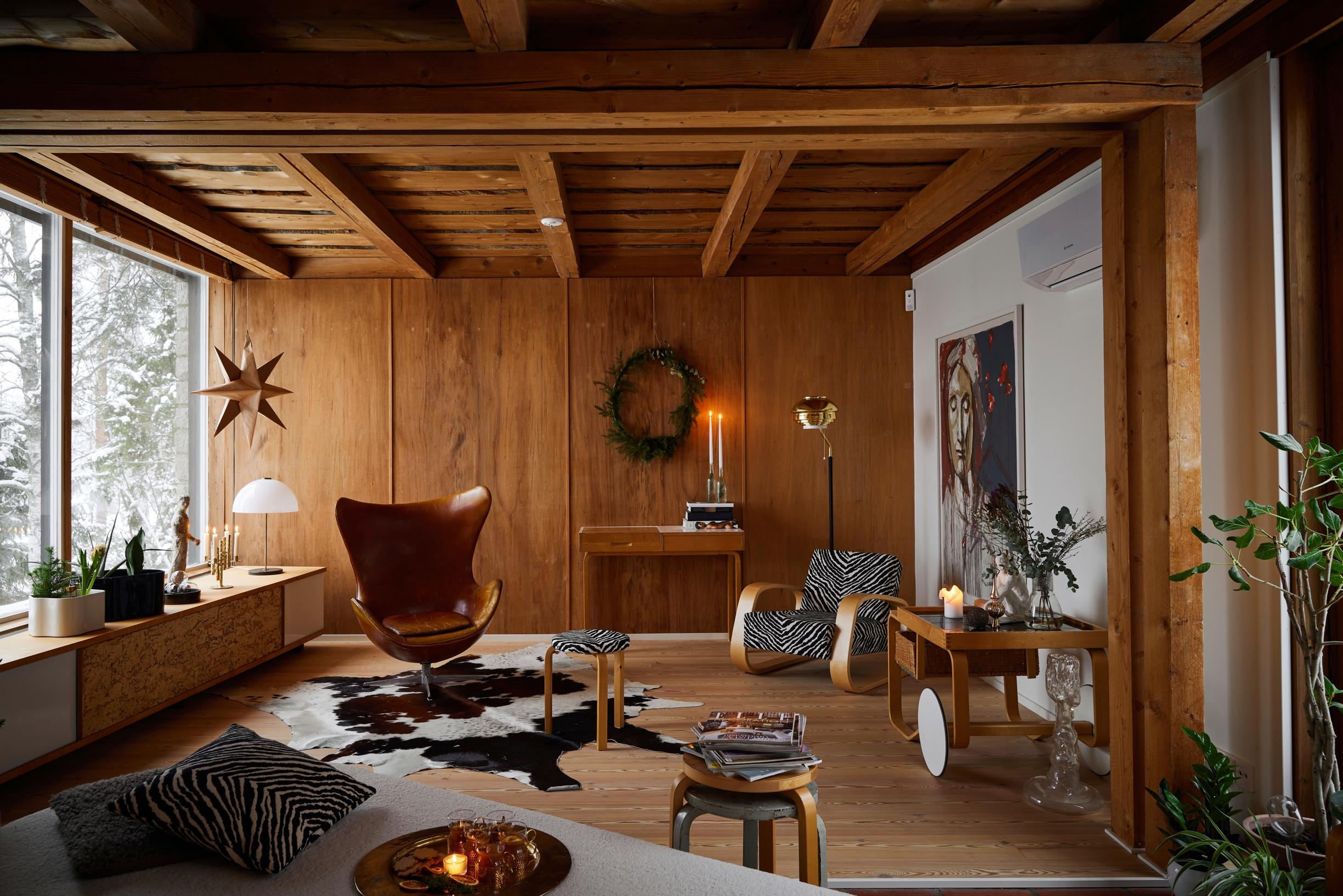 In the living room, an aged pine ceiling, wood veneer wall, and vintage design.