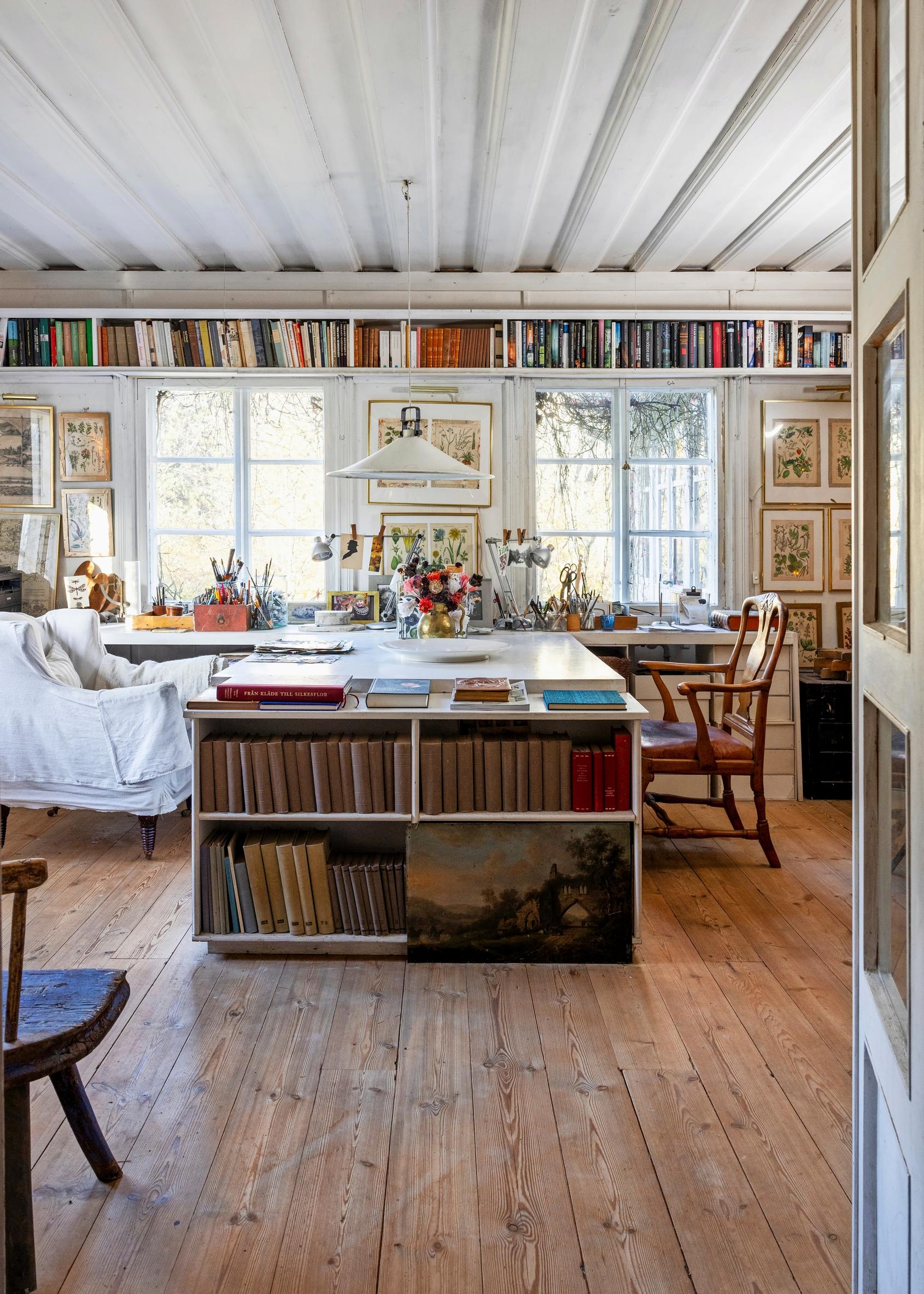 Library room with many books and a large desk in the center.