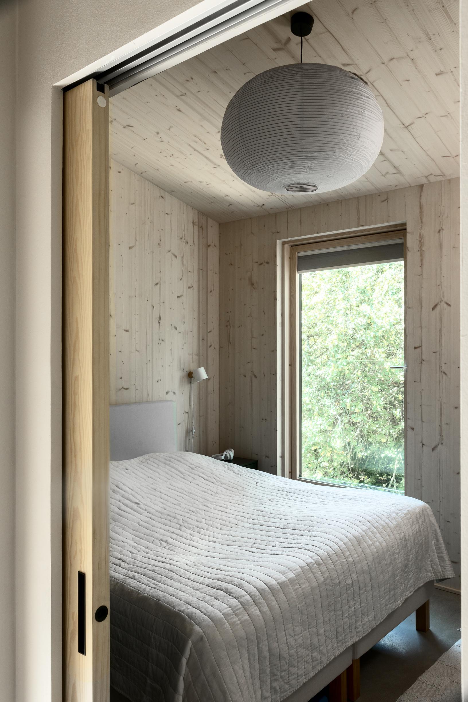 The bedroom has a bed and a large window