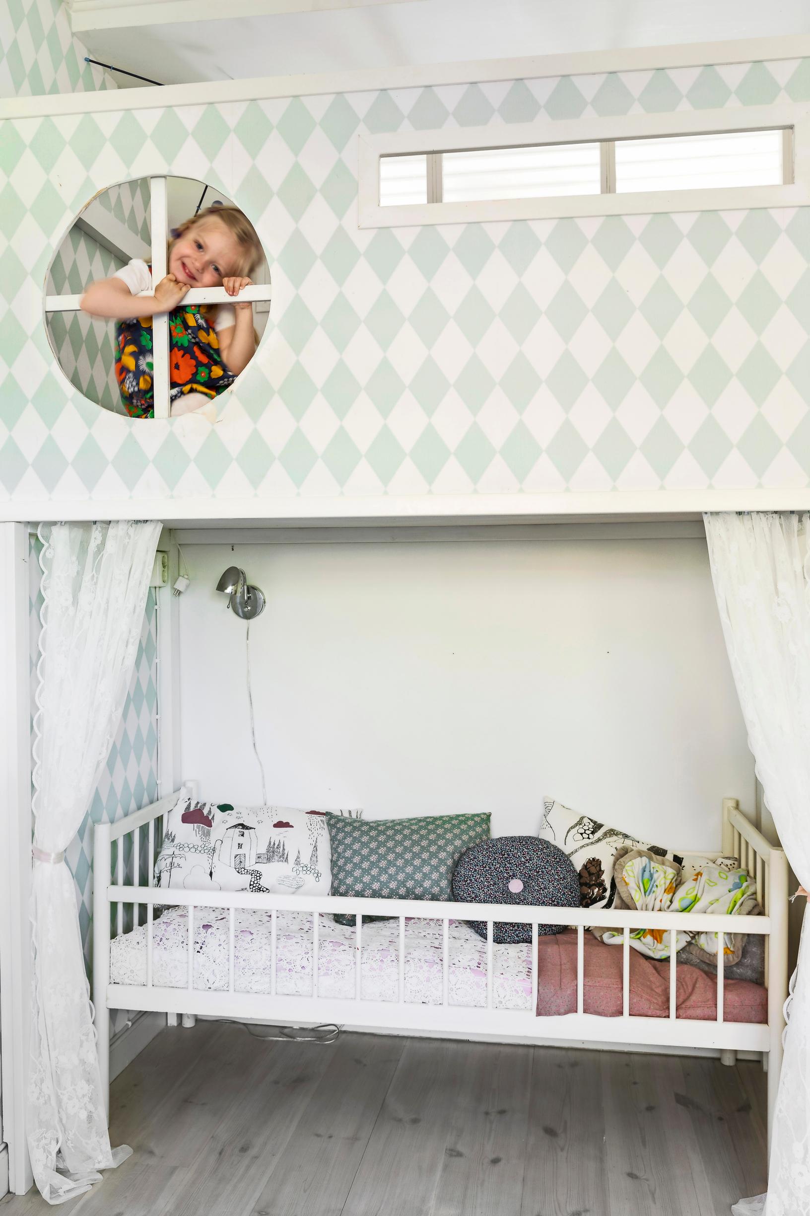 A child in a bunk bed in a children’s room.