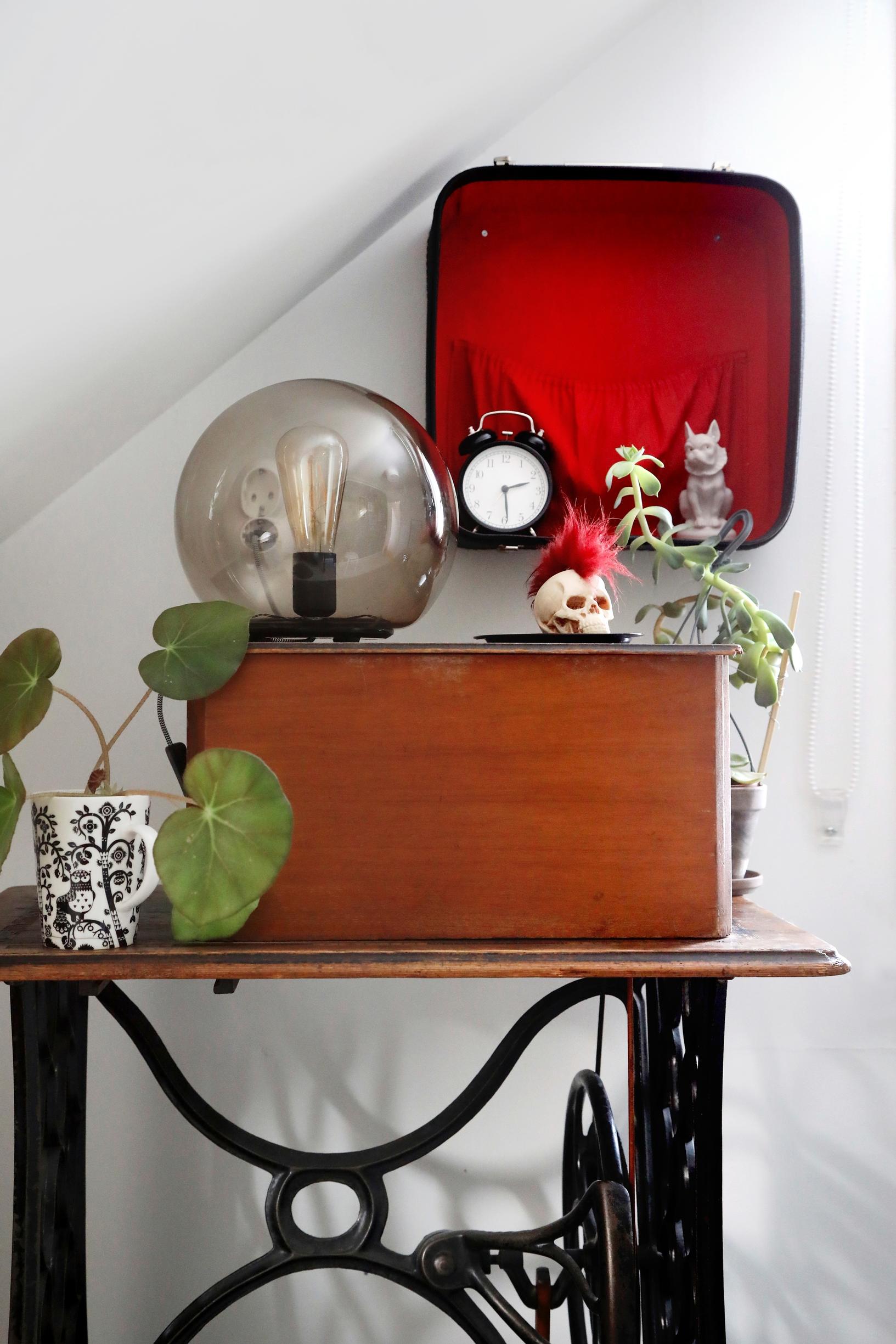 Unique decor items on top of an old sewing machine table