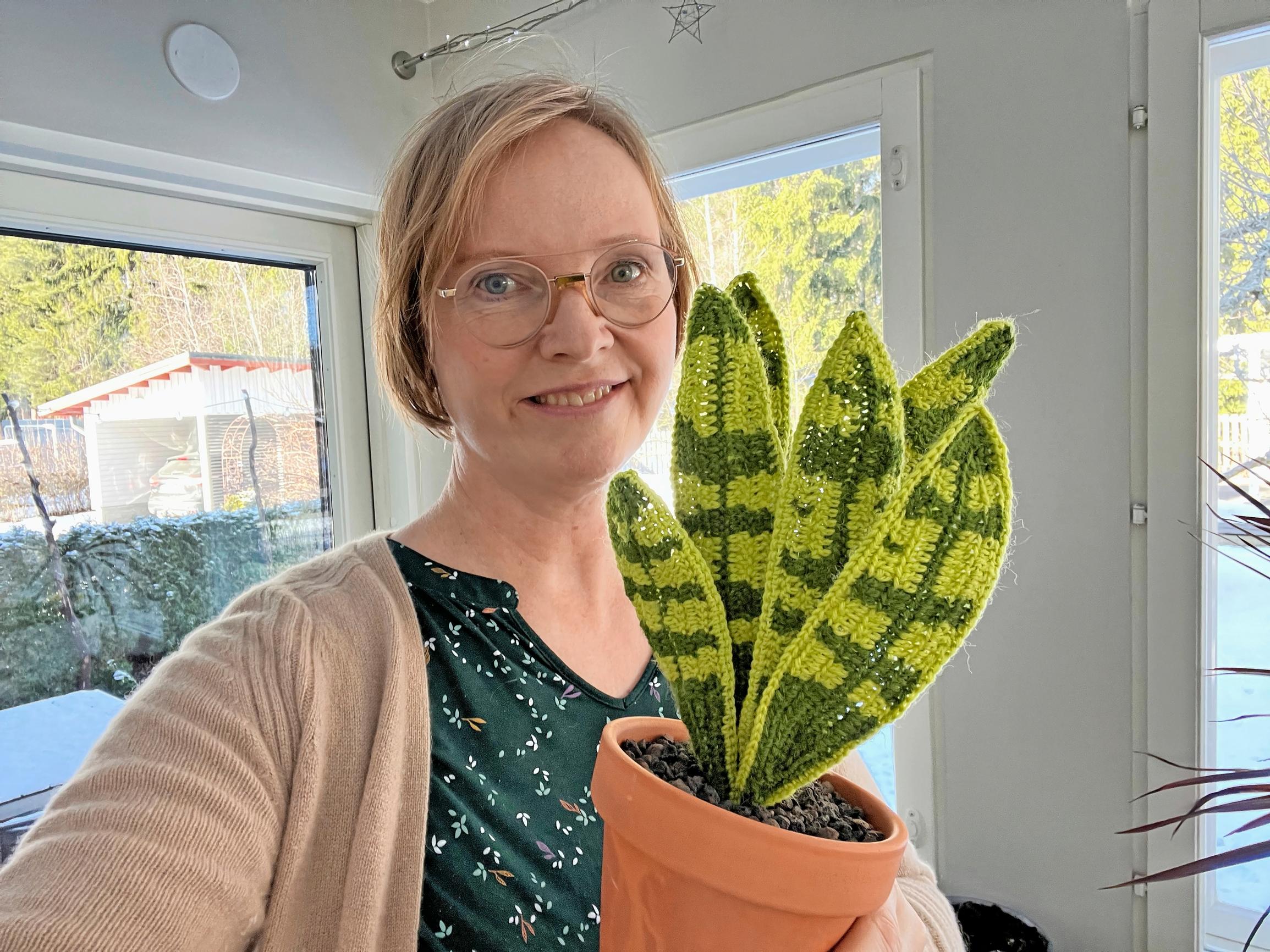 On Tiina’s lap is a large crocheted snake plant.