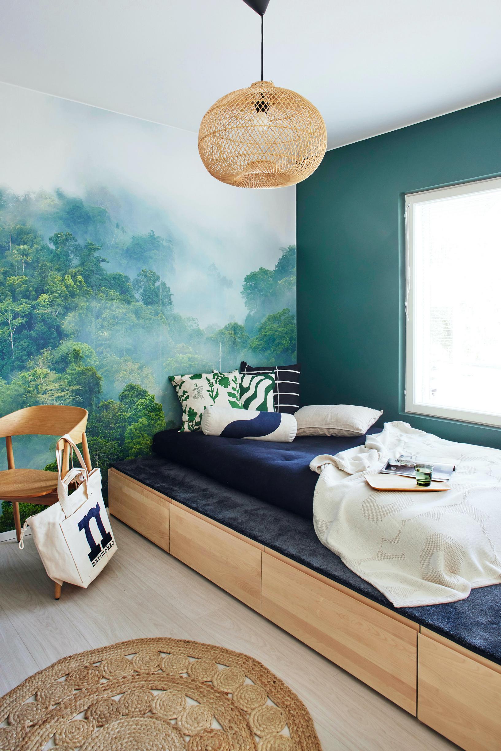 A wooden raised bed with storage drawers underneath, placed in front of the guest room window.