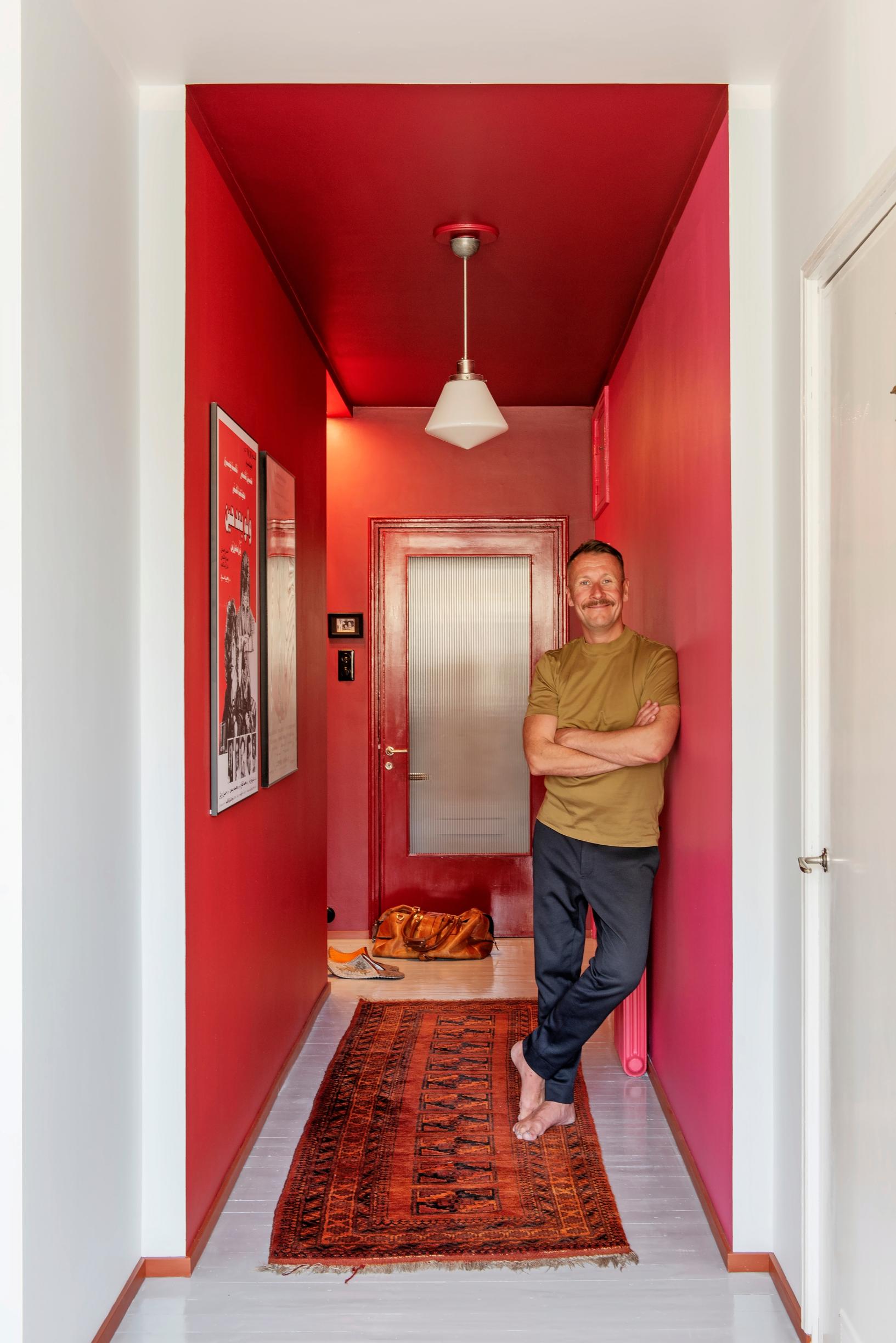 A red entryway with a red Oriental rug.