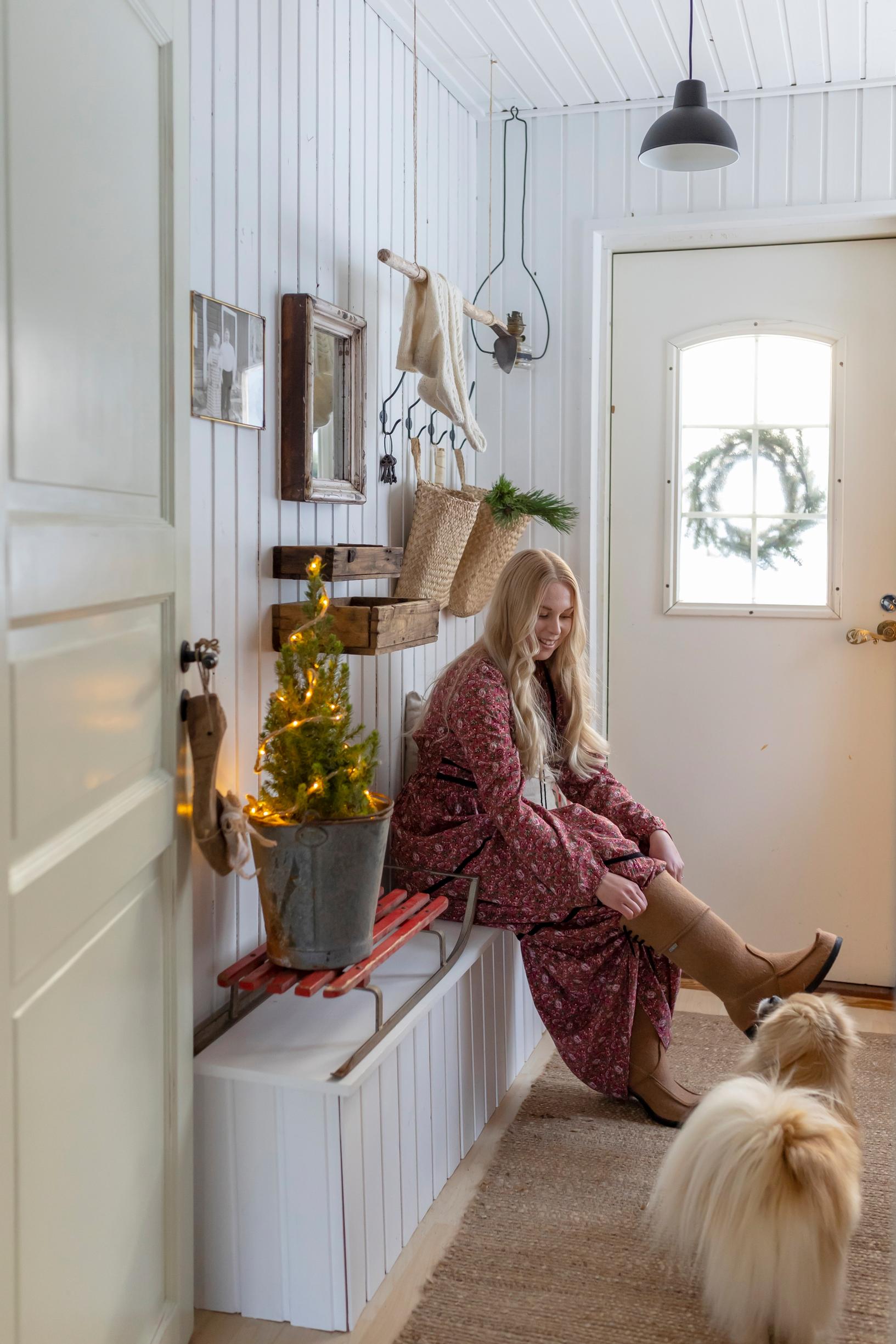 Meeri sits on the bench in the entryway