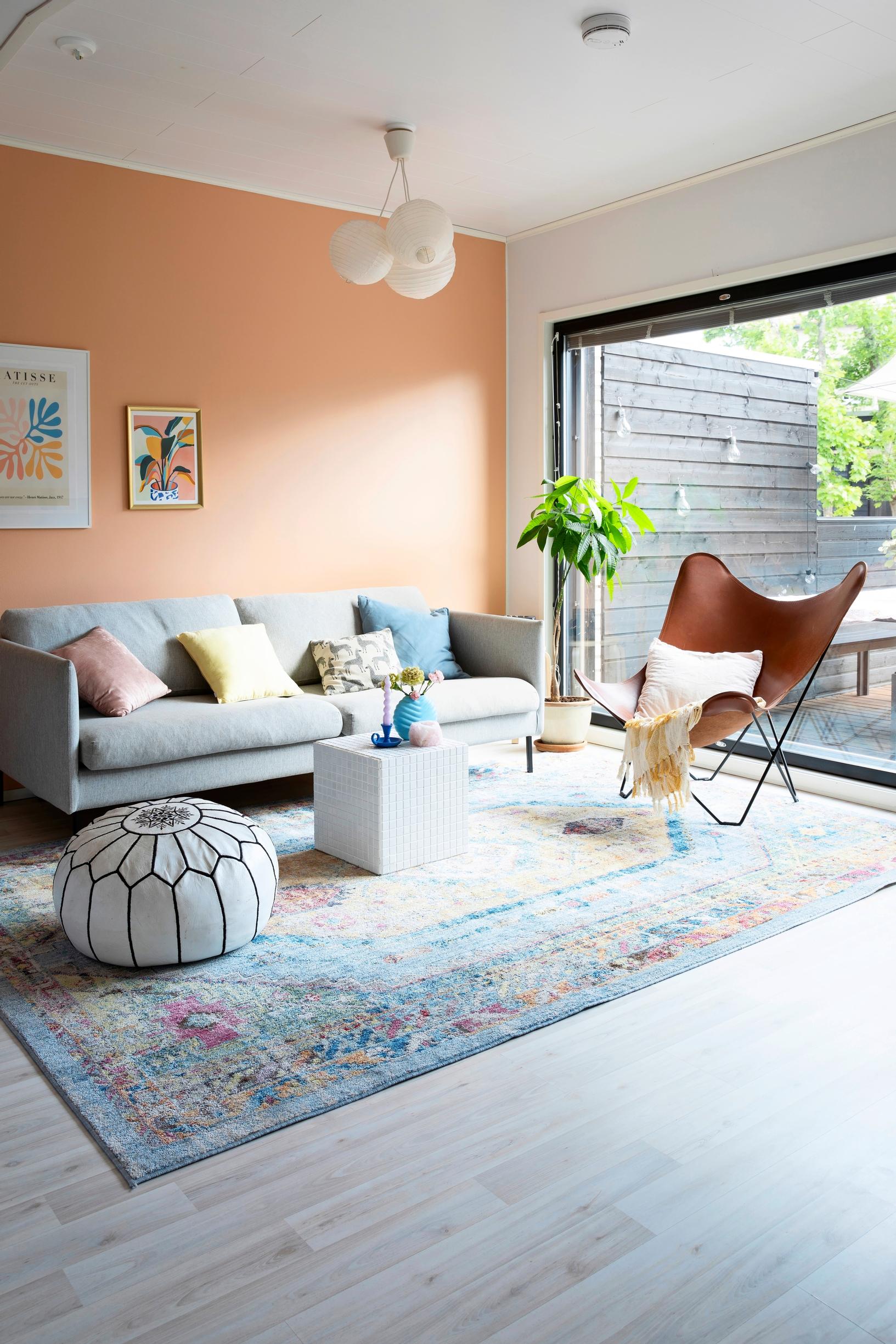 The living room has a peach-toned wall.