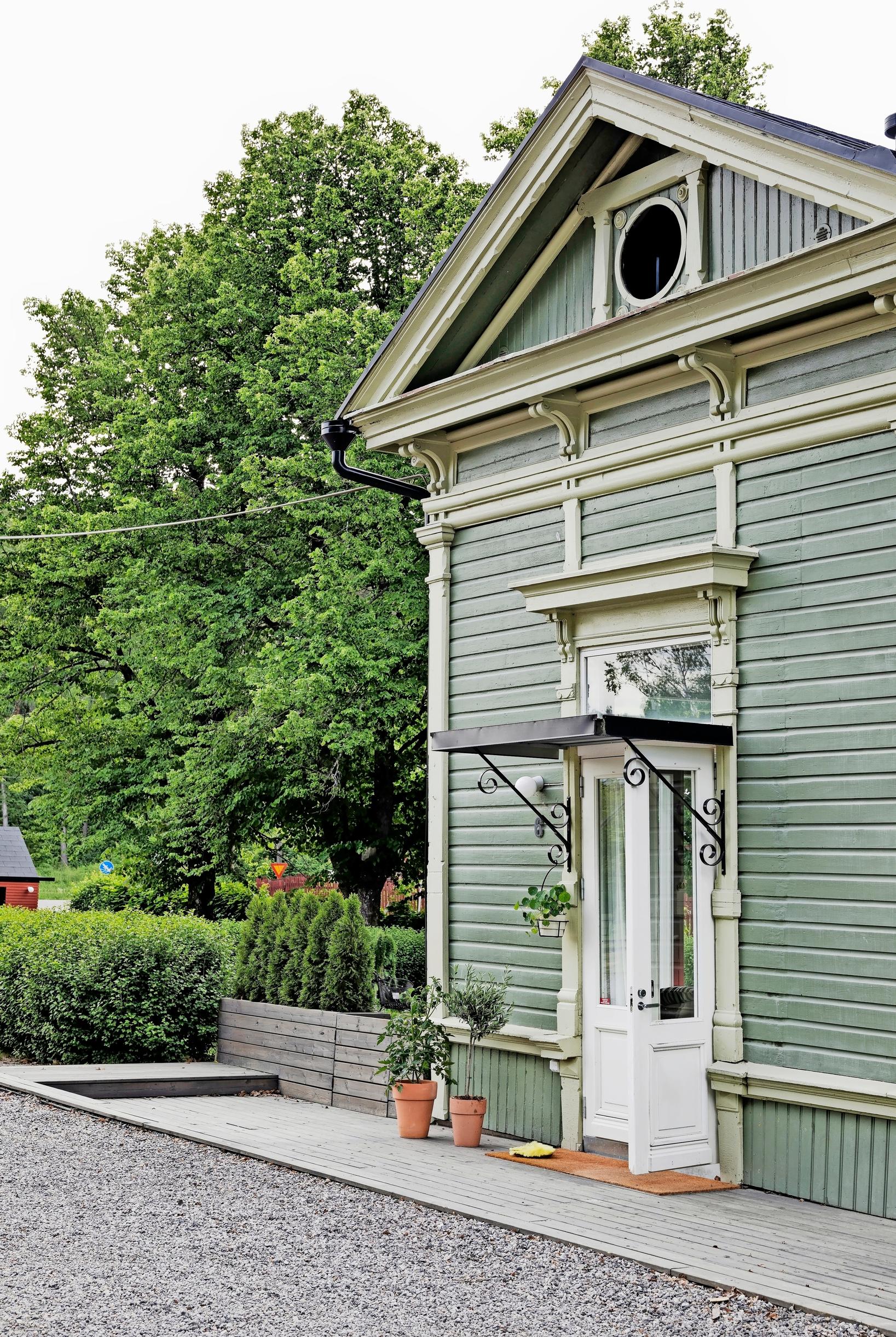 A green old wooden building and entrance.