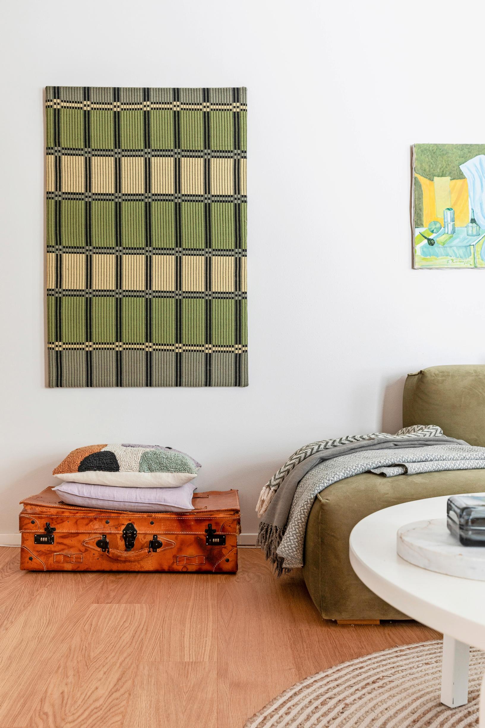 Photo of a living room with a thrifted wall hanging.