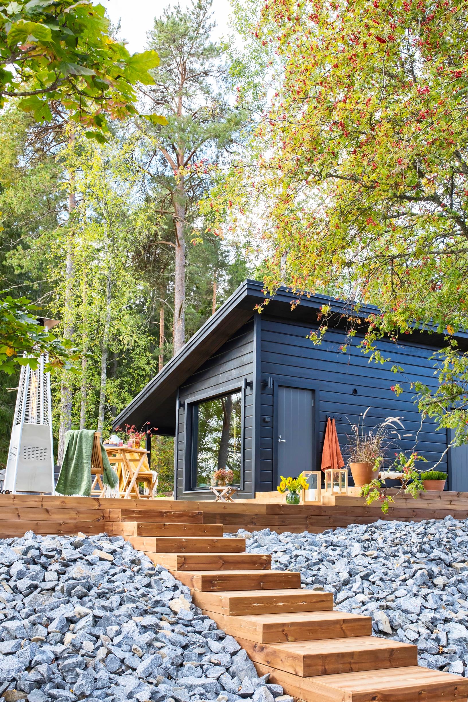 A black sauna cottage on a slope