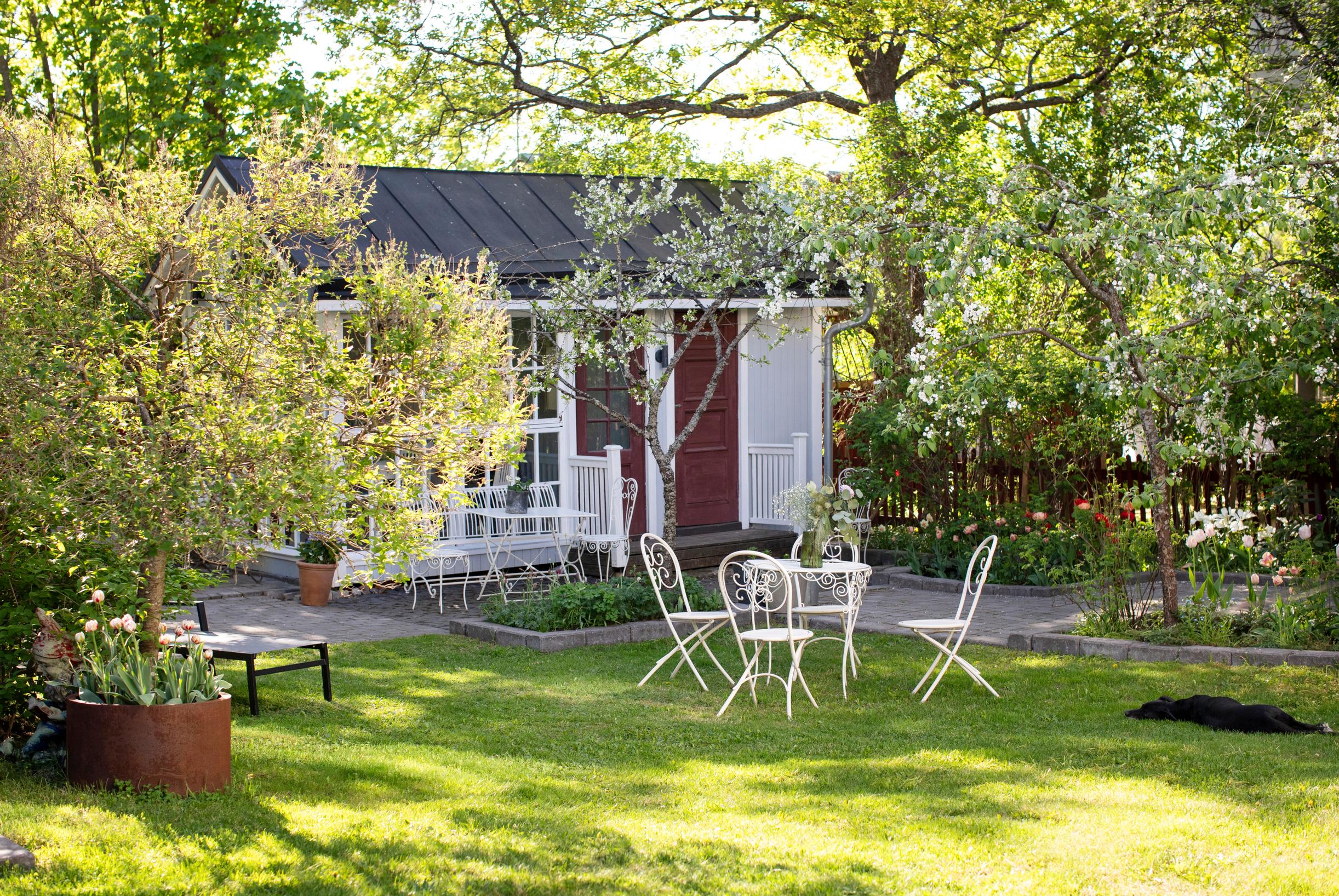 A garden cottage, lawn, and seating area.