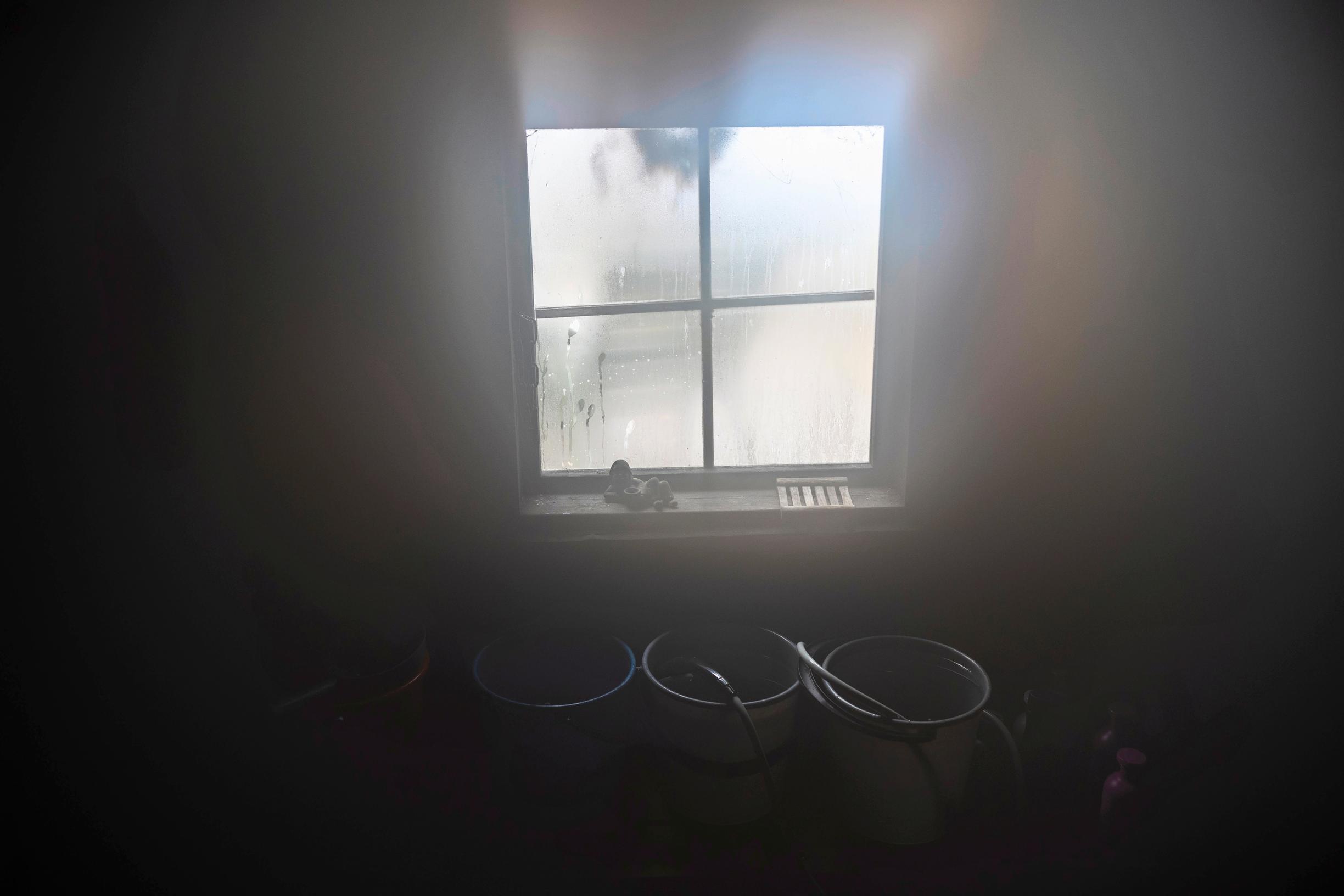Buckets in front of the dimly lit sauna’s window