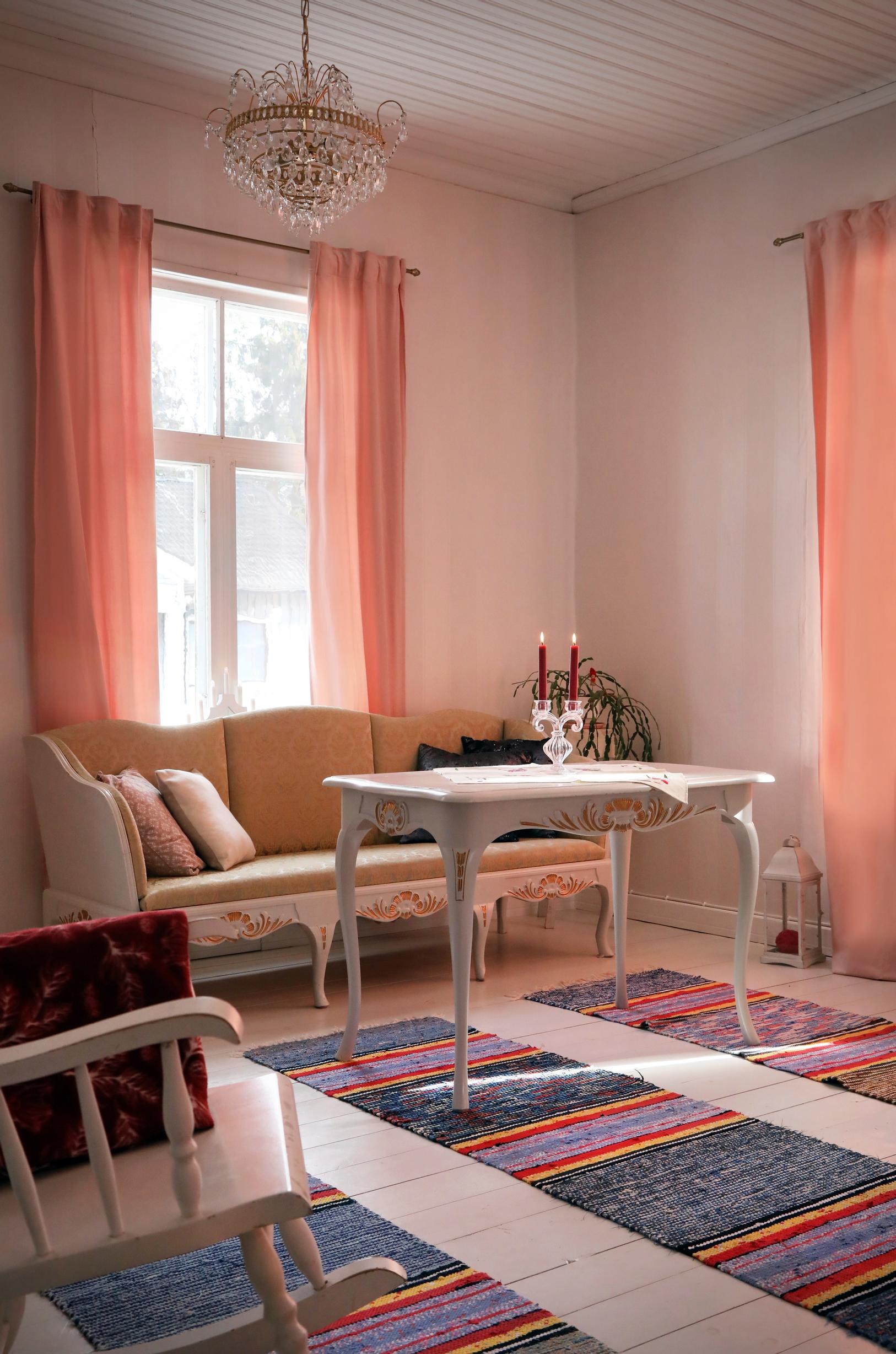 An old, decorative wooden sofa in front of the window