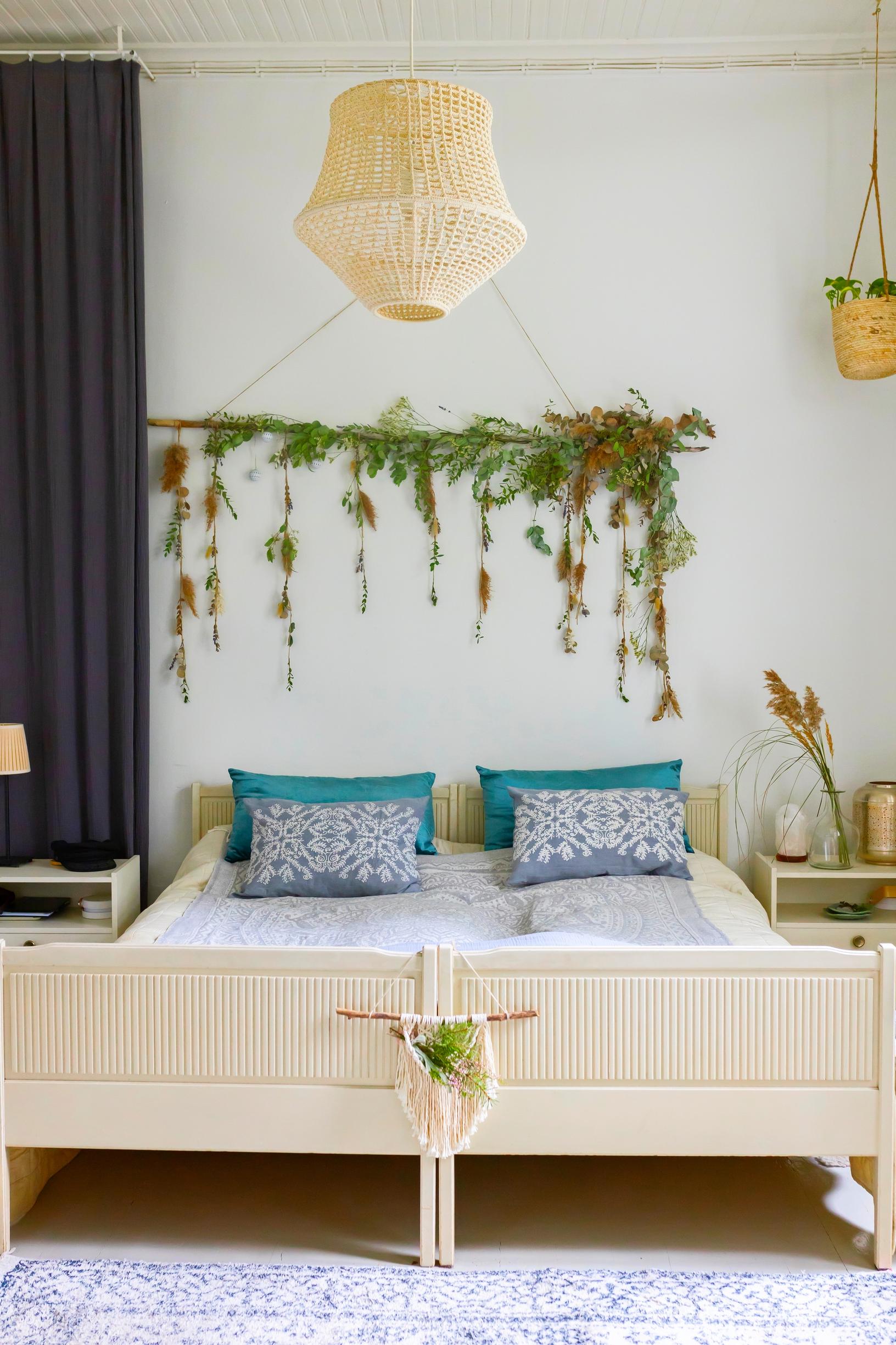 Bedroom with a double bed, plant wreath on the wall.