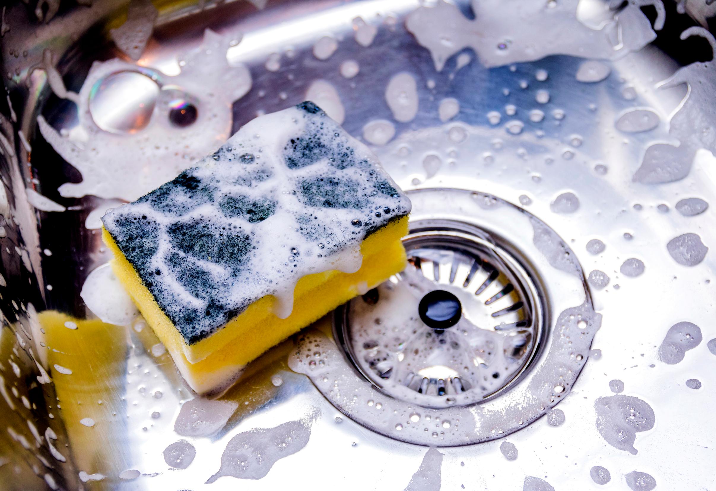 Cleaning the sink with a sponge