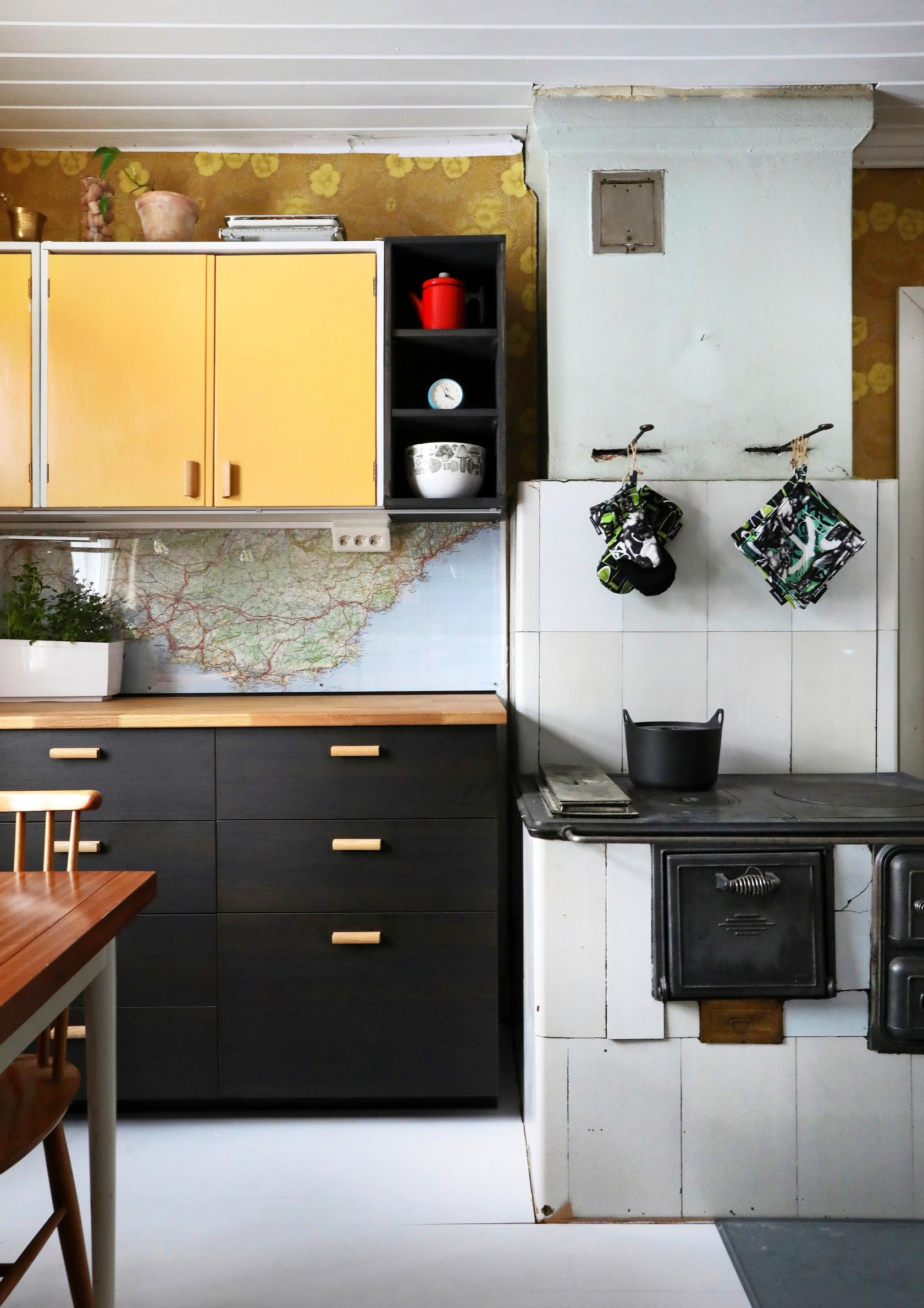 Yellow solid-wood cabinets and black Ikea units in the kitchen