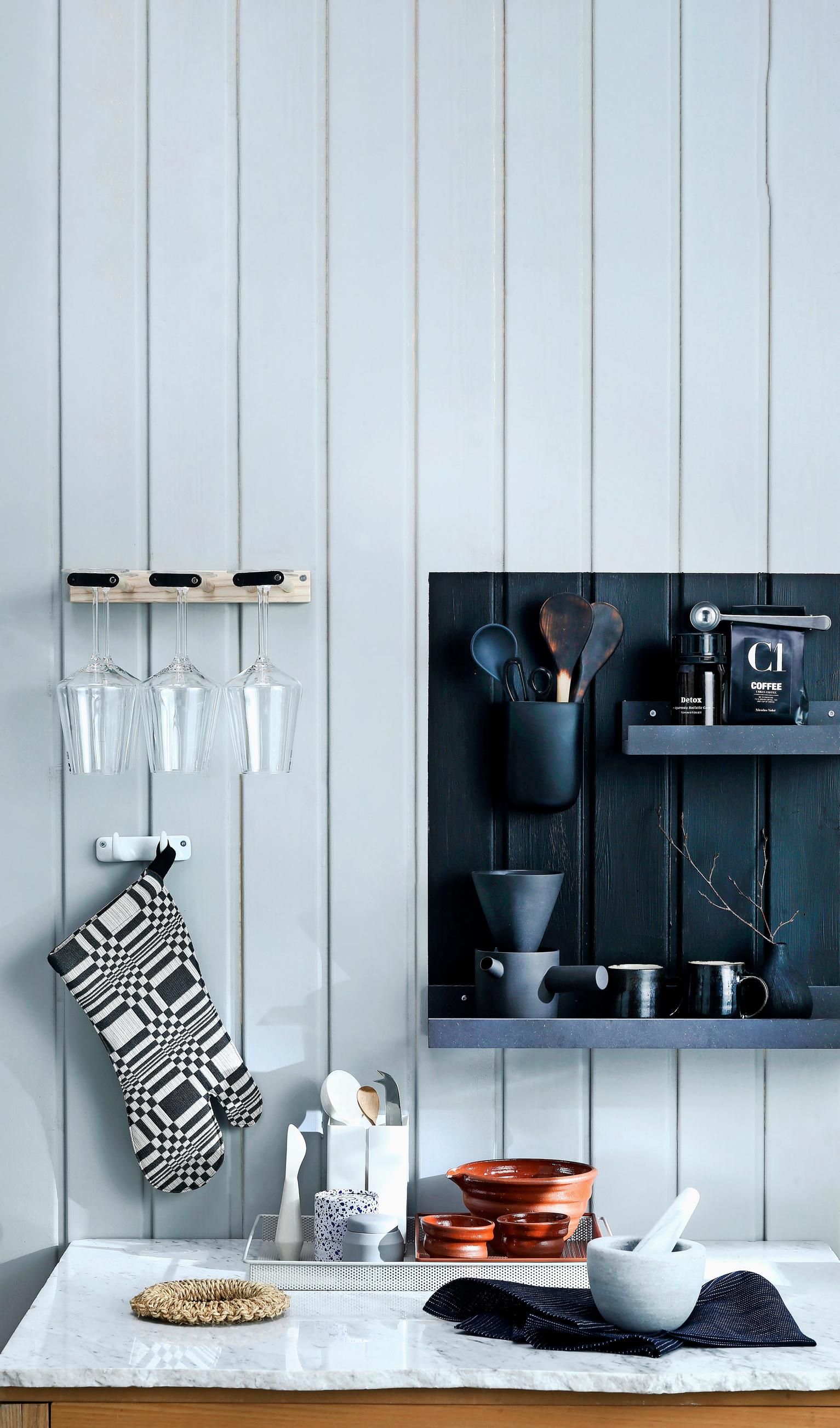 A black-painted square behind black open shelves
