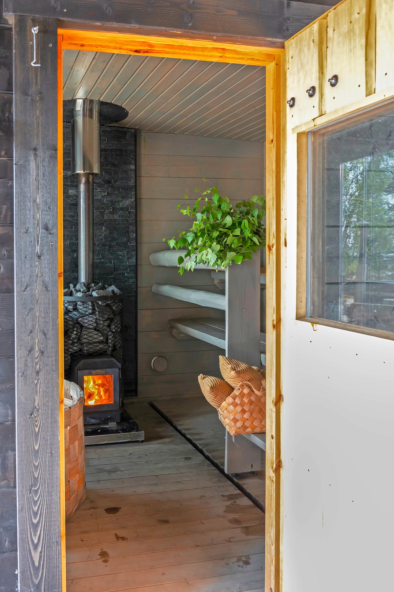 gray sauna benches and a soapstone stove in the sauna, a birch whisk