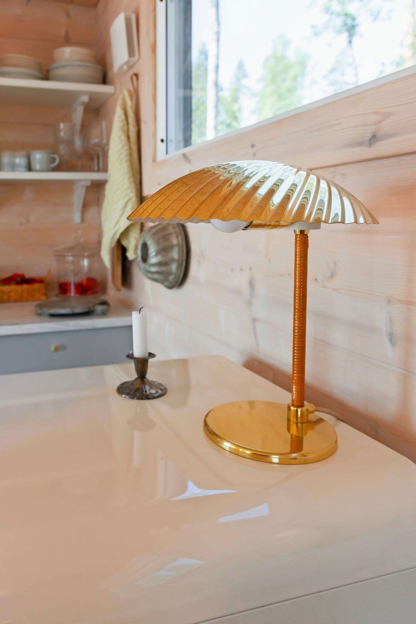 A Tynell Simpukka lamp on a table under the window