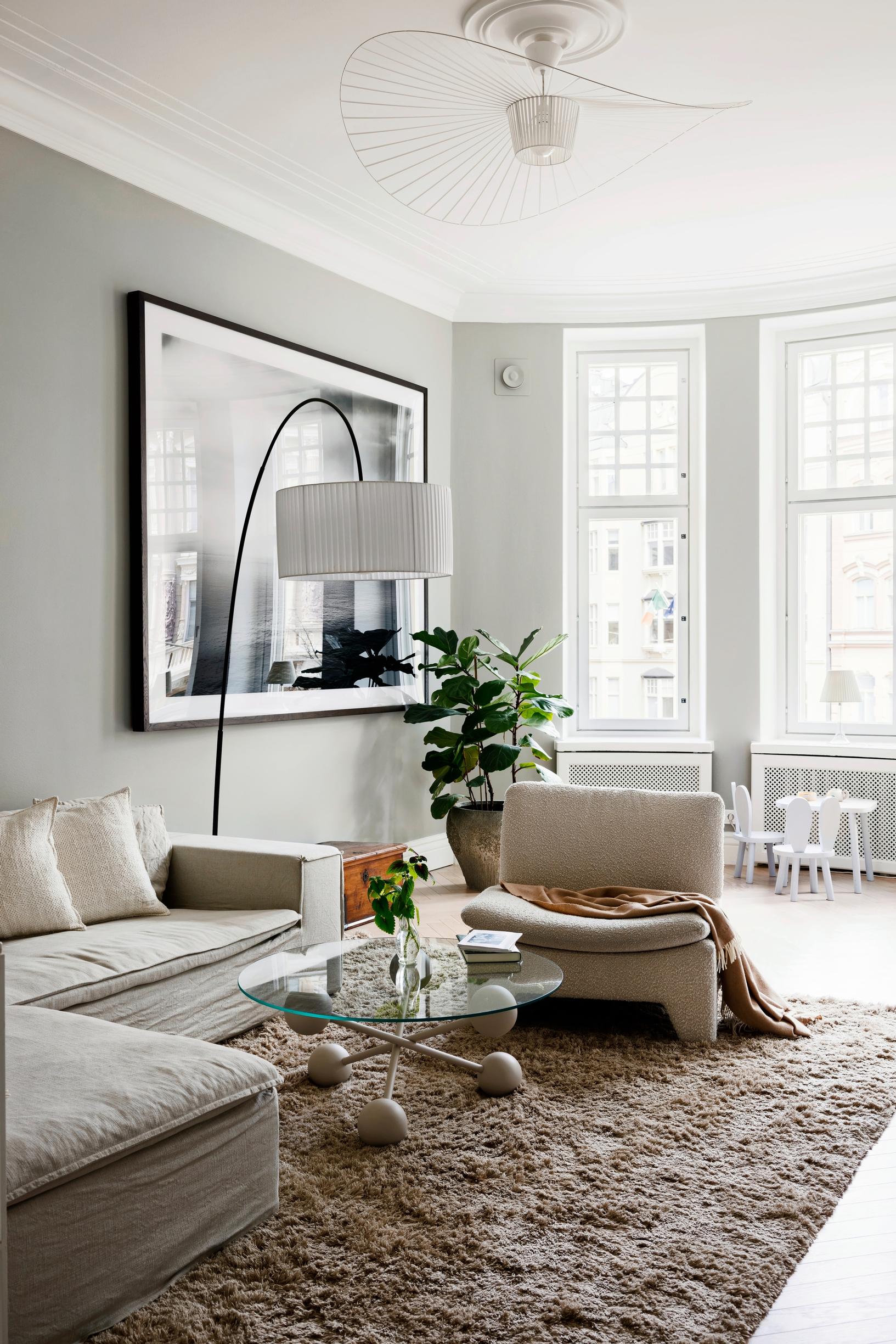 The TV room’s sofa and armchair, plus a small-paned window in the bay area.