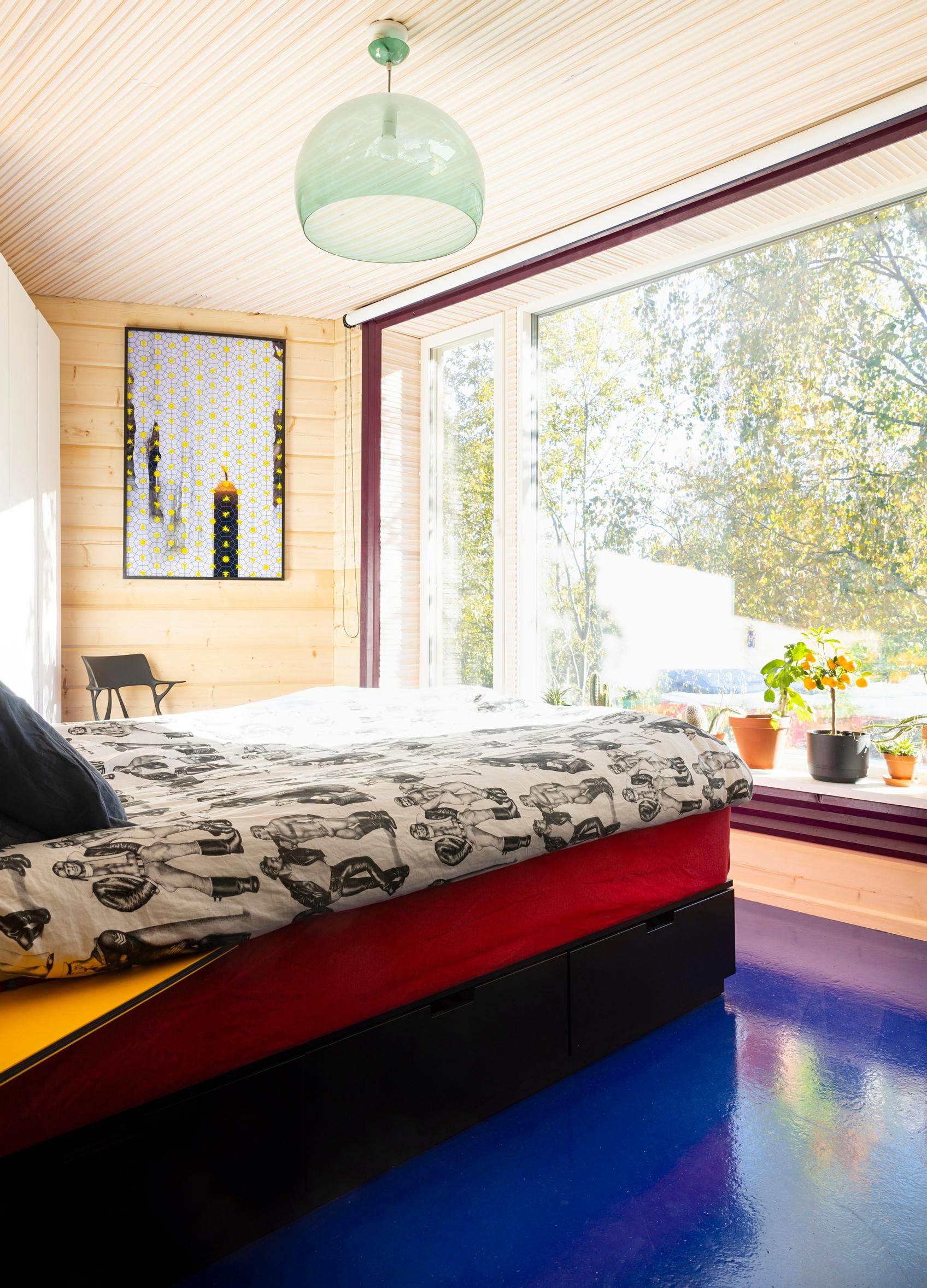 The bedroom’s large window and blue floor