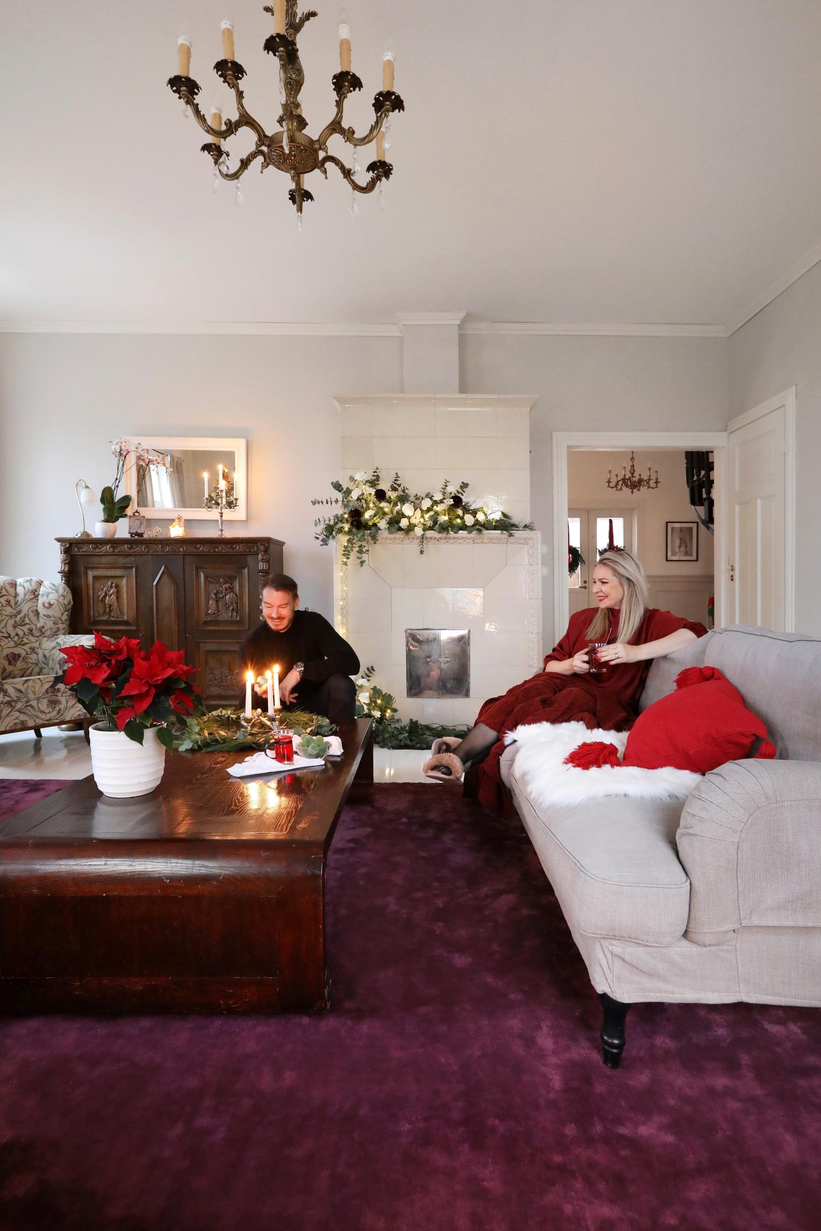 A light-colored living room furnished with dark wooden furniture and a large plum-colored rug