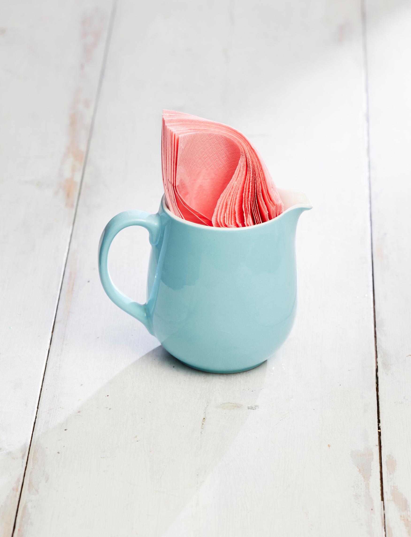 An old Arabia milk pitcher holding napkins.