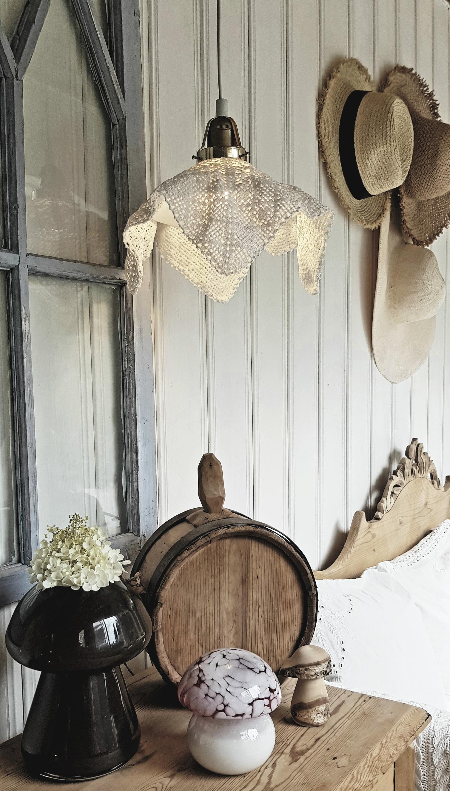 A small, angular lace doily rests atop a shoemaker’s lamp.