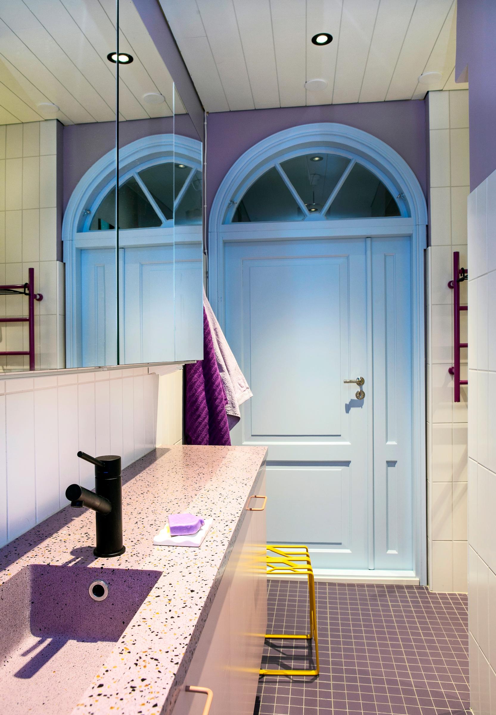 Bathroom featuring lilac tiles and blue accents