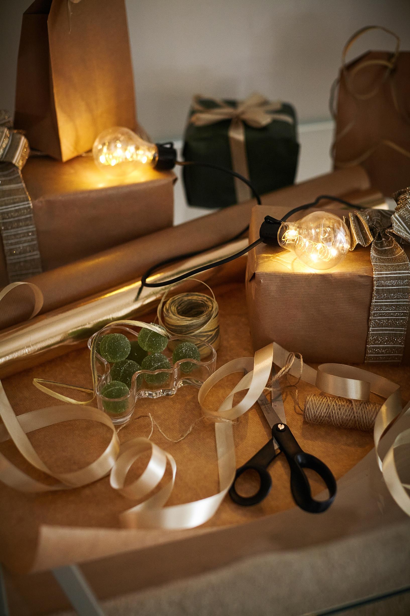 gift ribbon, a present, and scissors with a string of Christmas lights