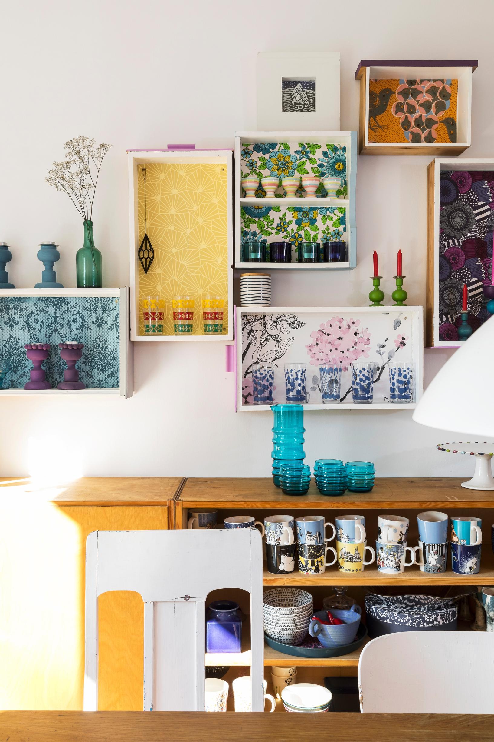 The dresser’s drawers have been mounted upright on the wall as shelves, with wallpapered bottoms.