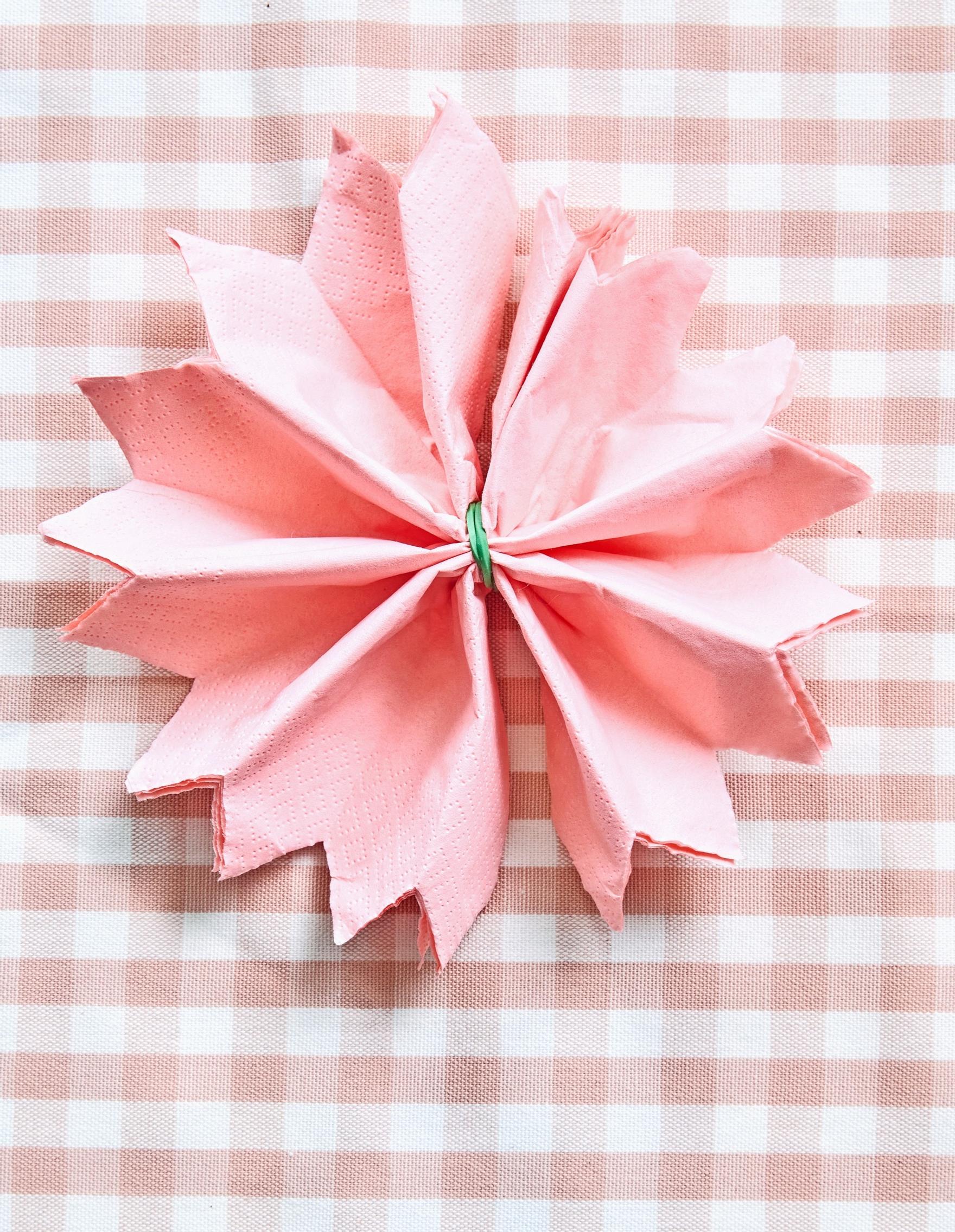 The accordion-folded napkin is opened upright.