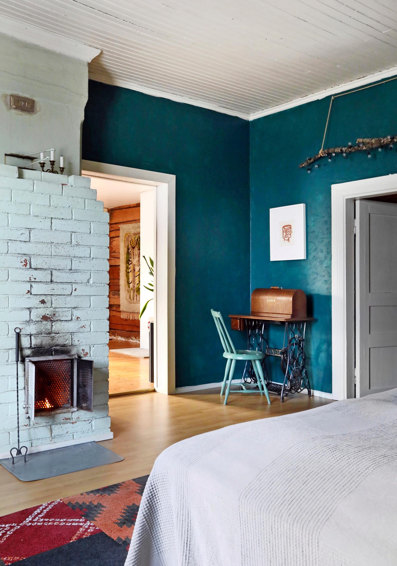 A bedroom fireplace and turquoise walls