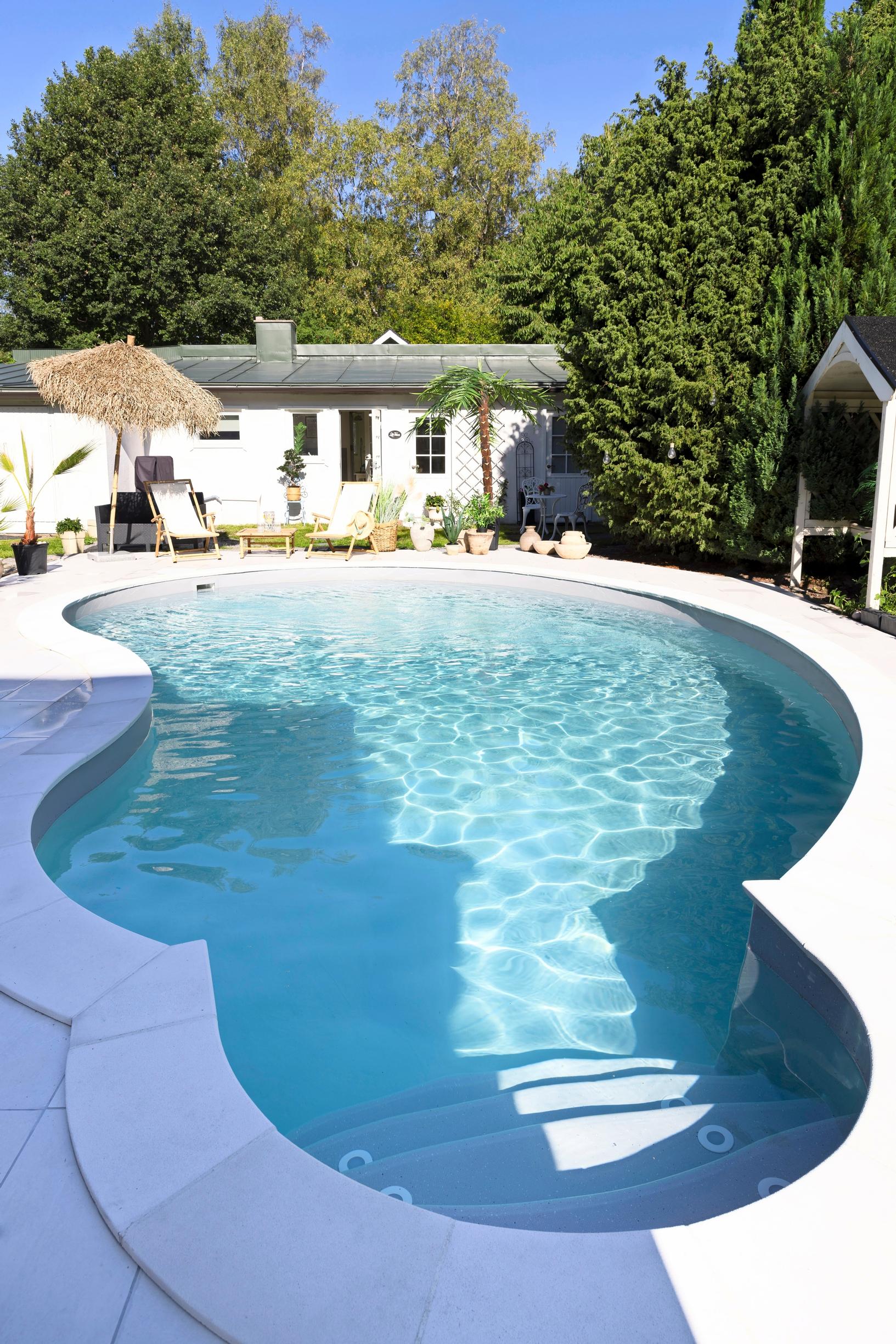 At the far end of the pool is a seating area and a low-profile building.
