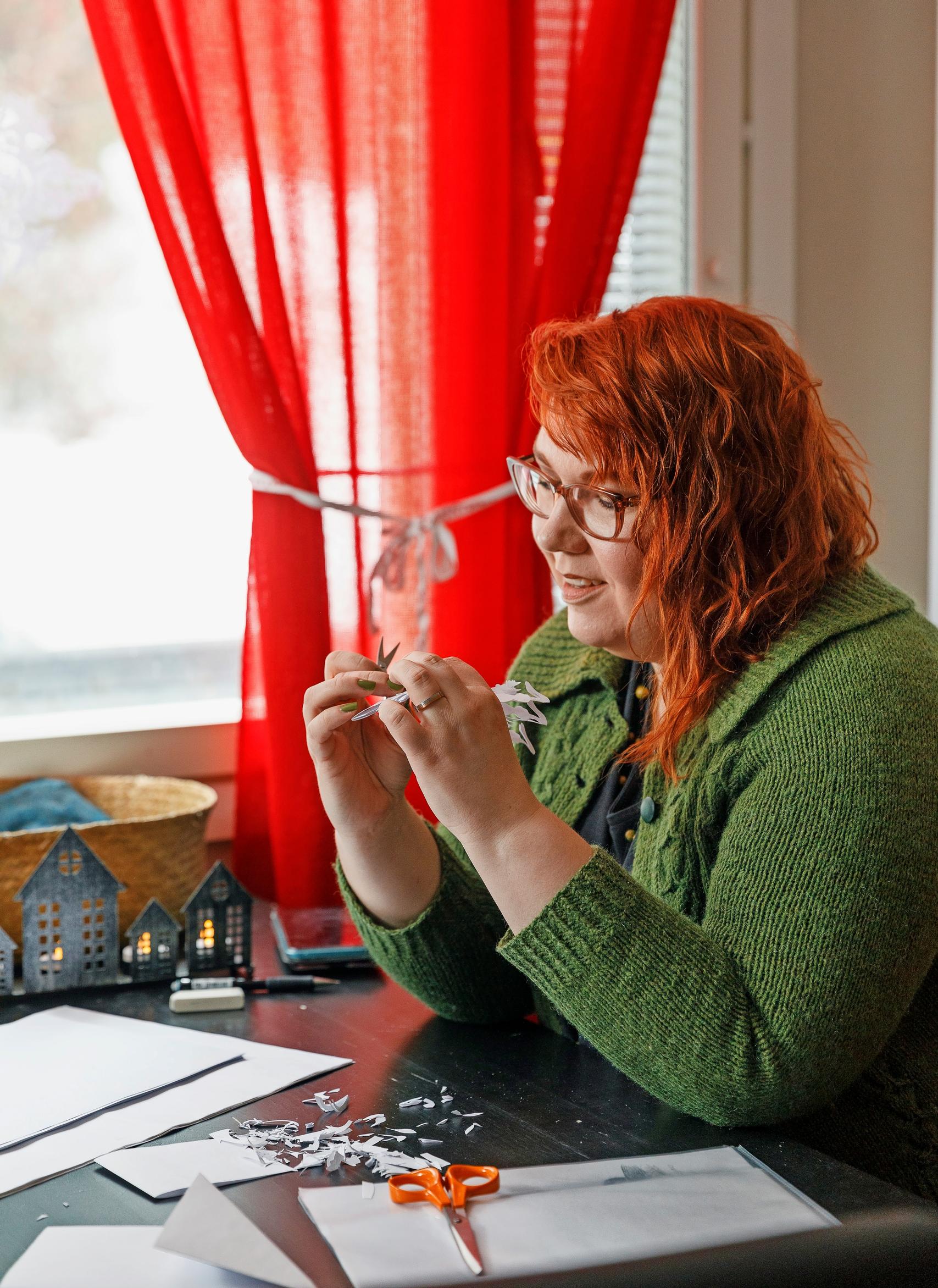 Venla cutting a paper star at the table.